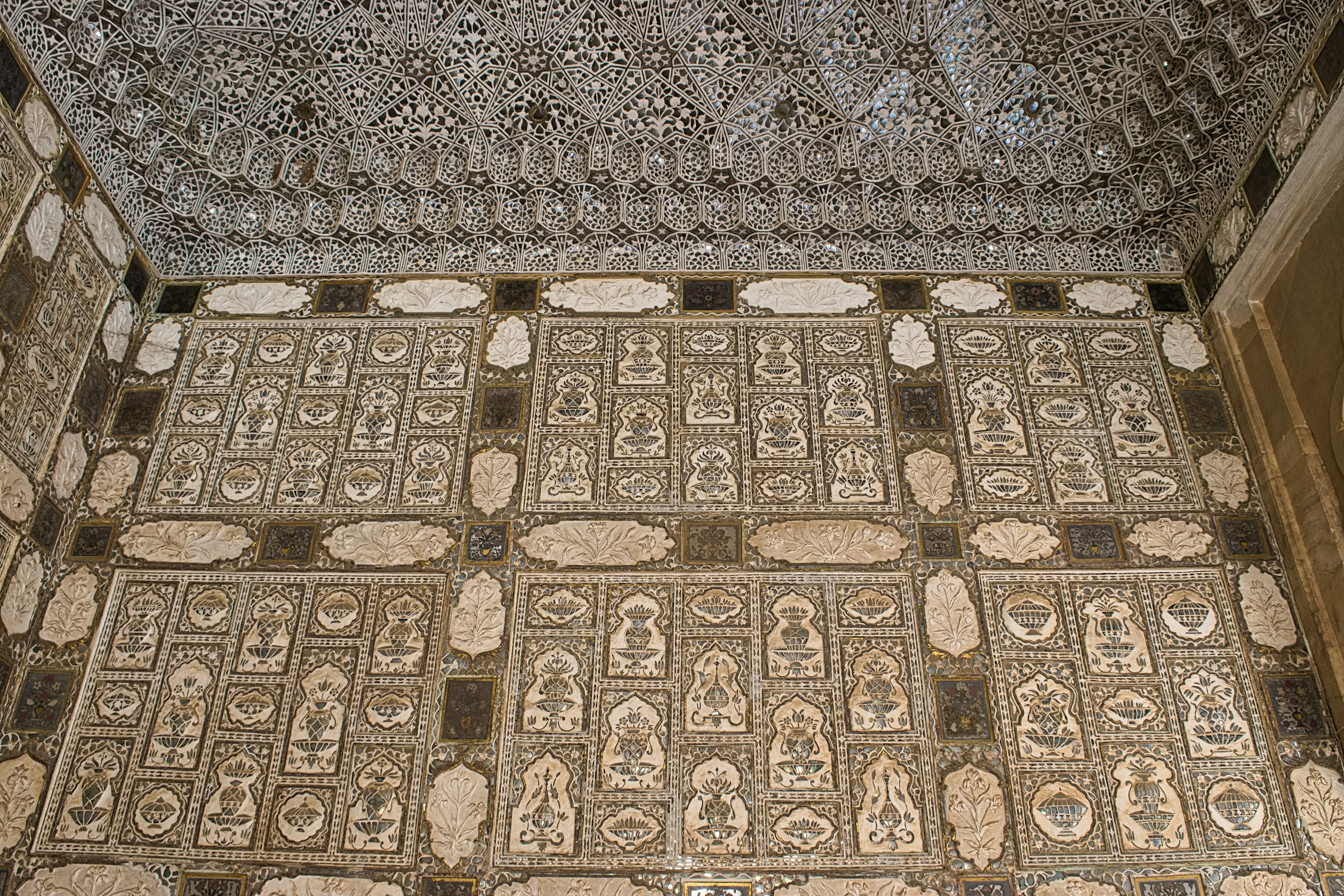 Chambre avec des carreaux décoratifs et des motifs muraux complexes