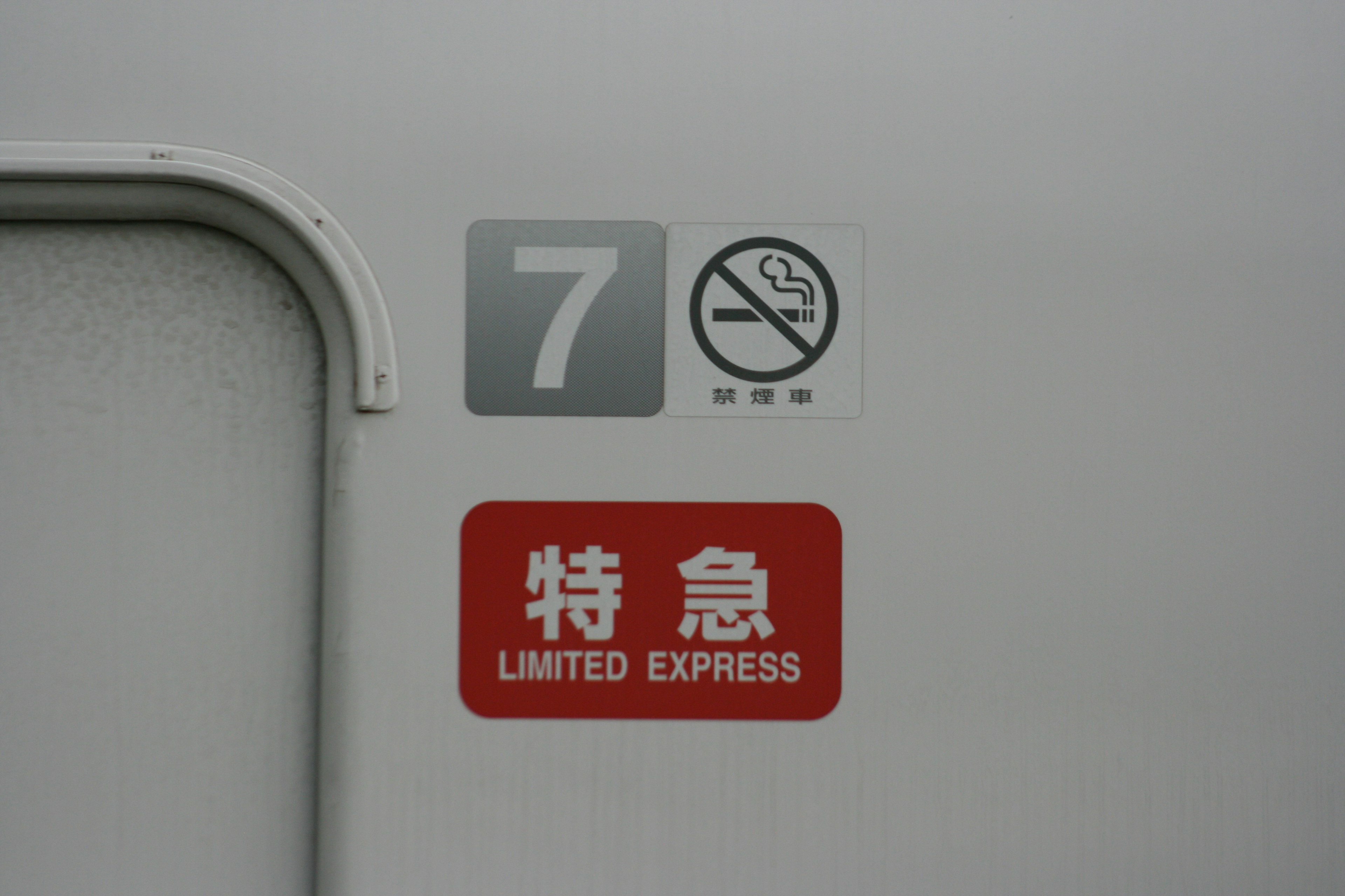 Door of limited express train car 7 featuring no smoking sign and limited express label