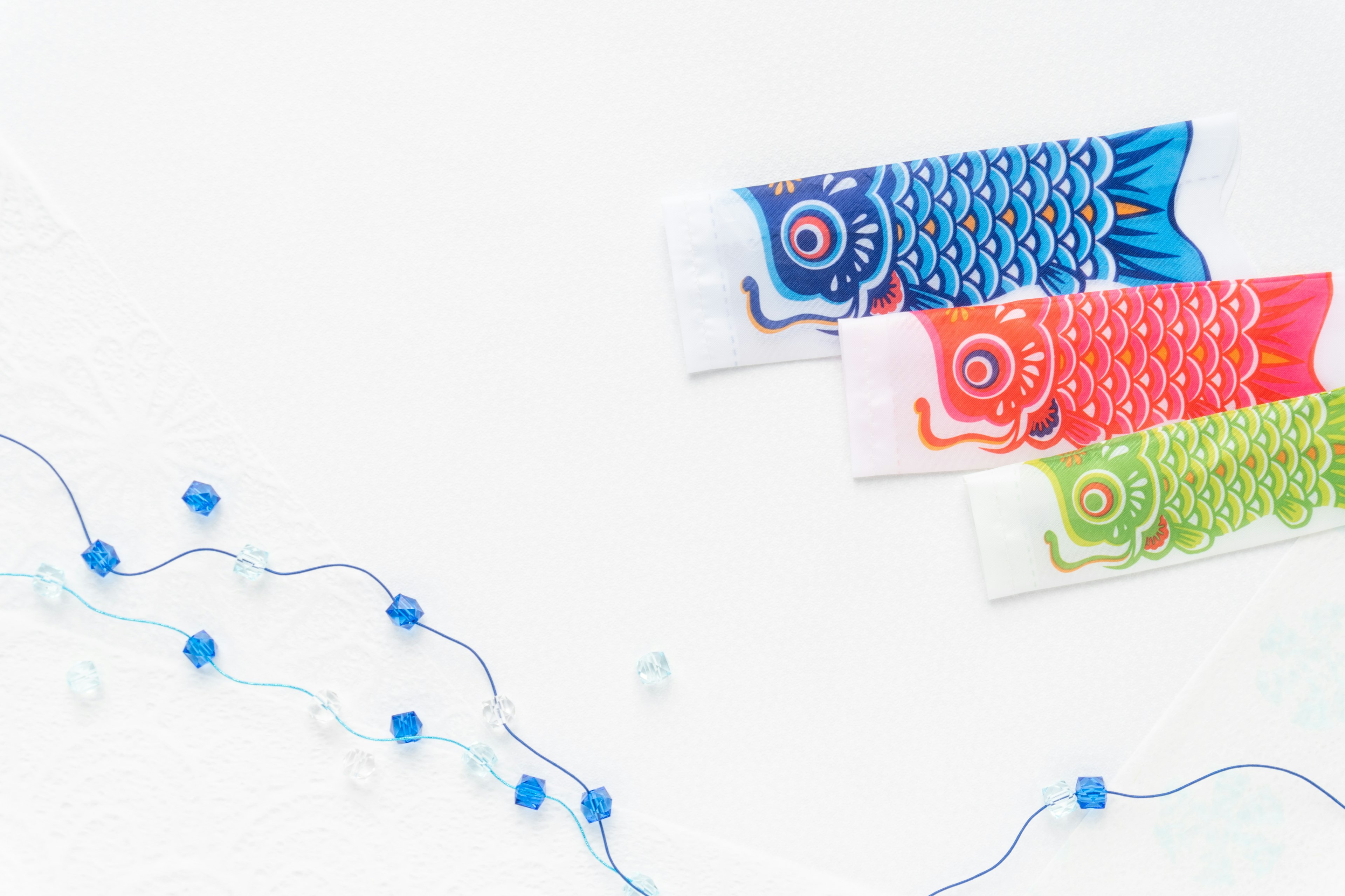 Colorful koi nobori on a white background with blue bead decorations