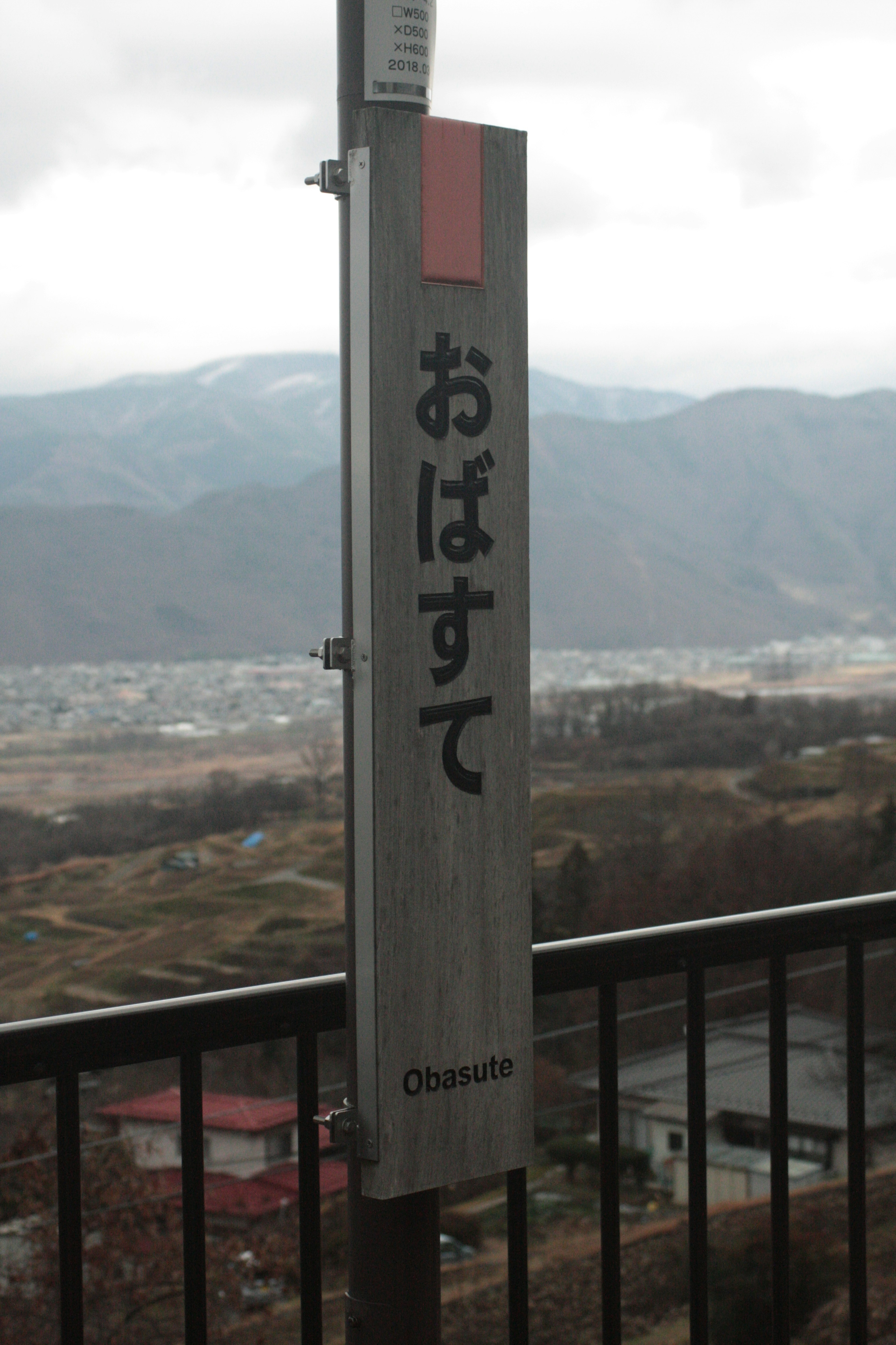 Schild für Obasute mit Bergen im Hintergrund