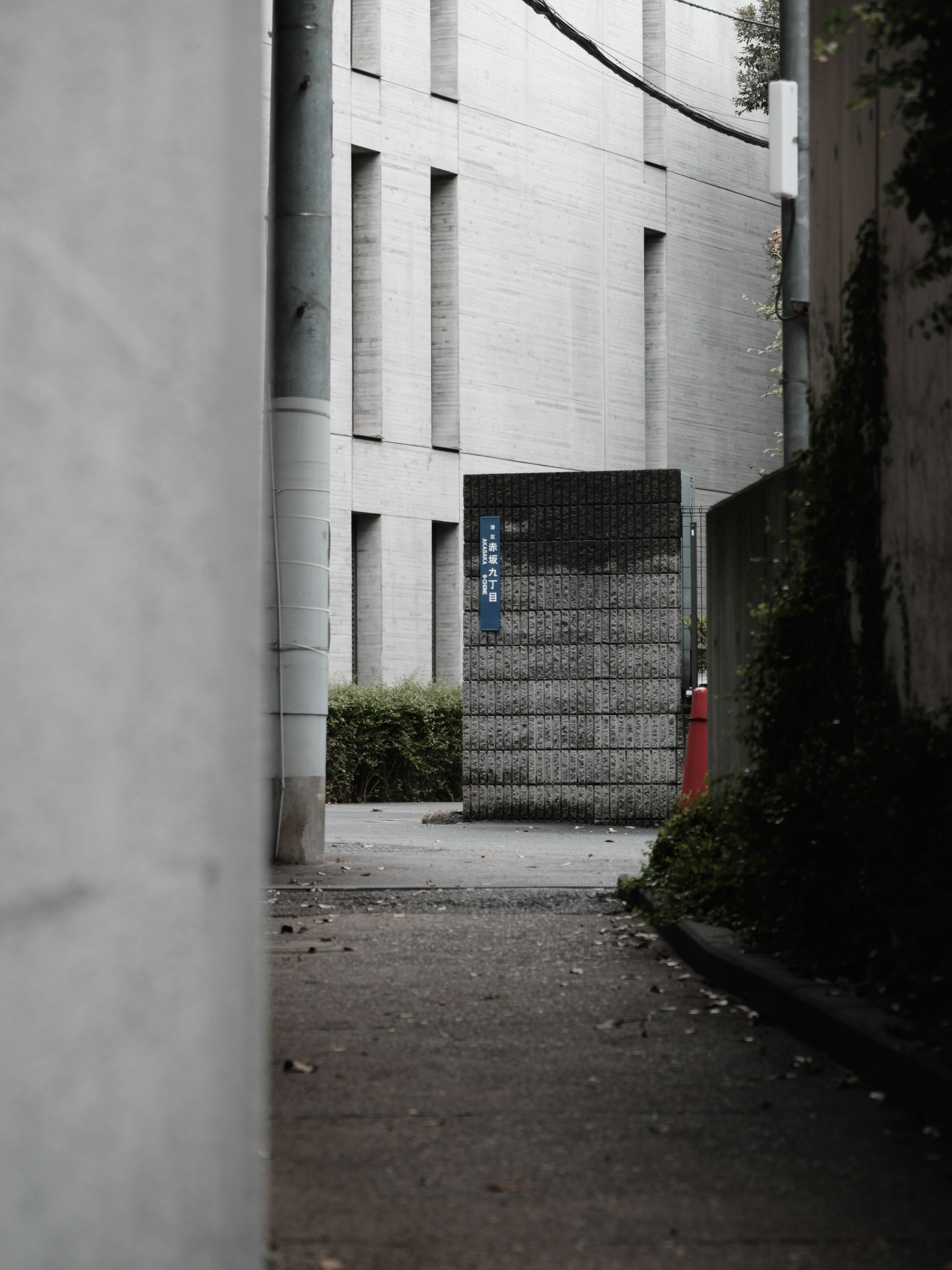 Callejón estrecho con pared de bloques y fachadas de edificios