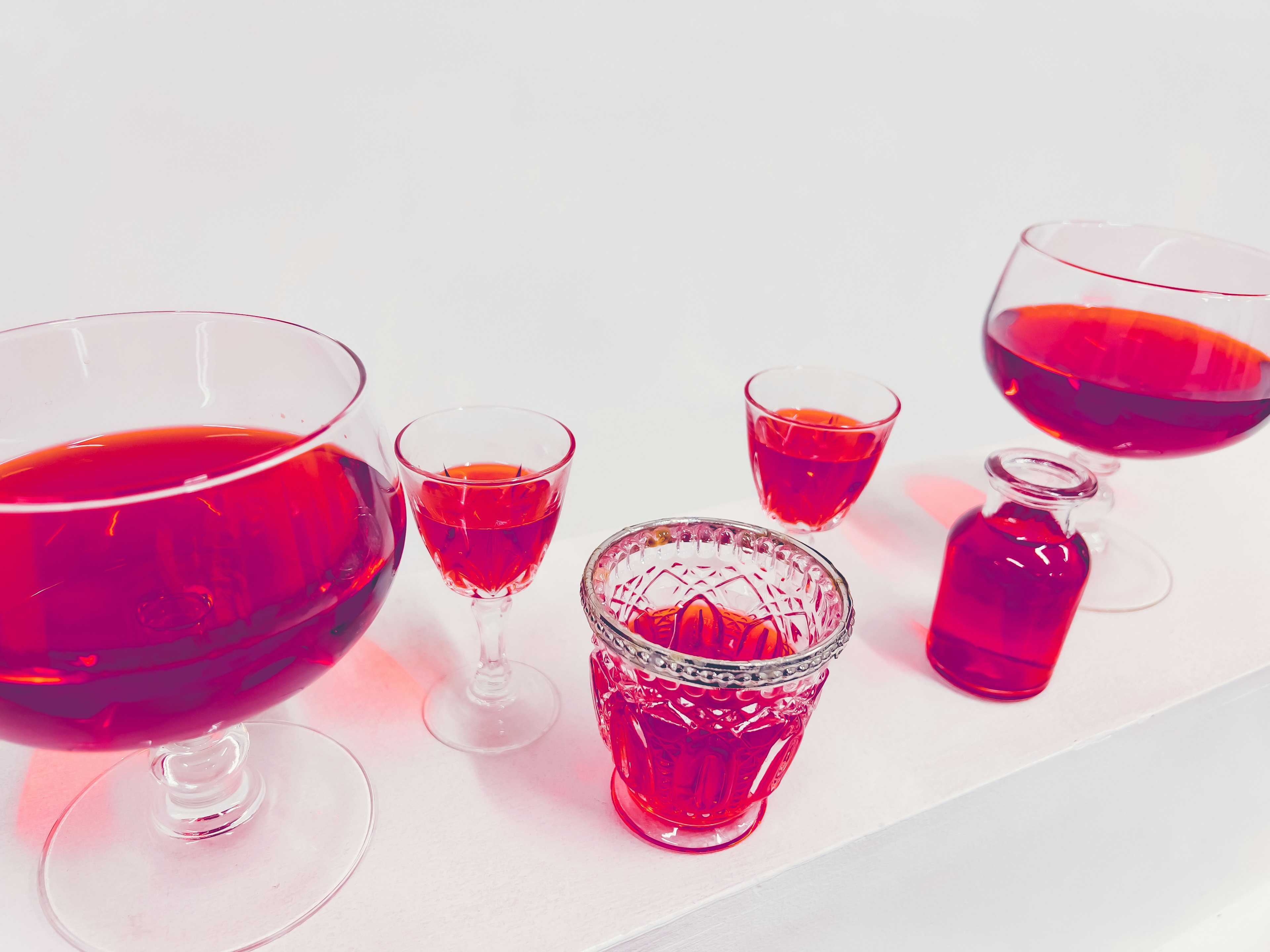 Scene featuring glass containers filled with red beverages