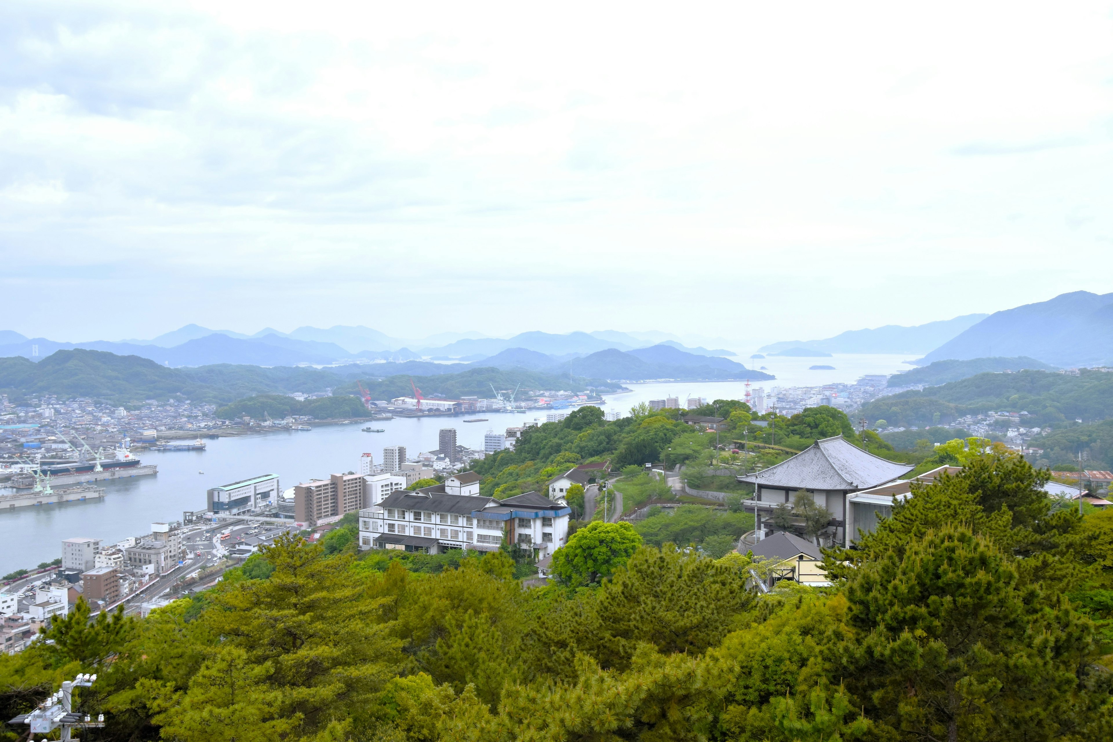 Scenic view of coastline and mountains with a river and city