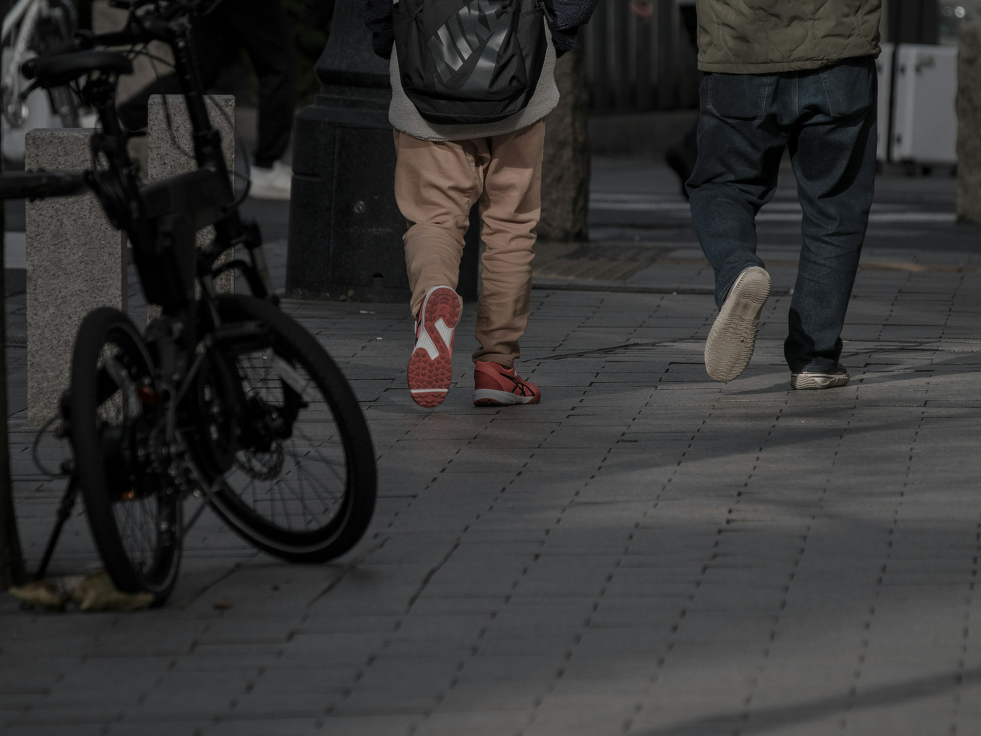 Scena di pedoni che camminano con una bicicletta parcheggiata vicino