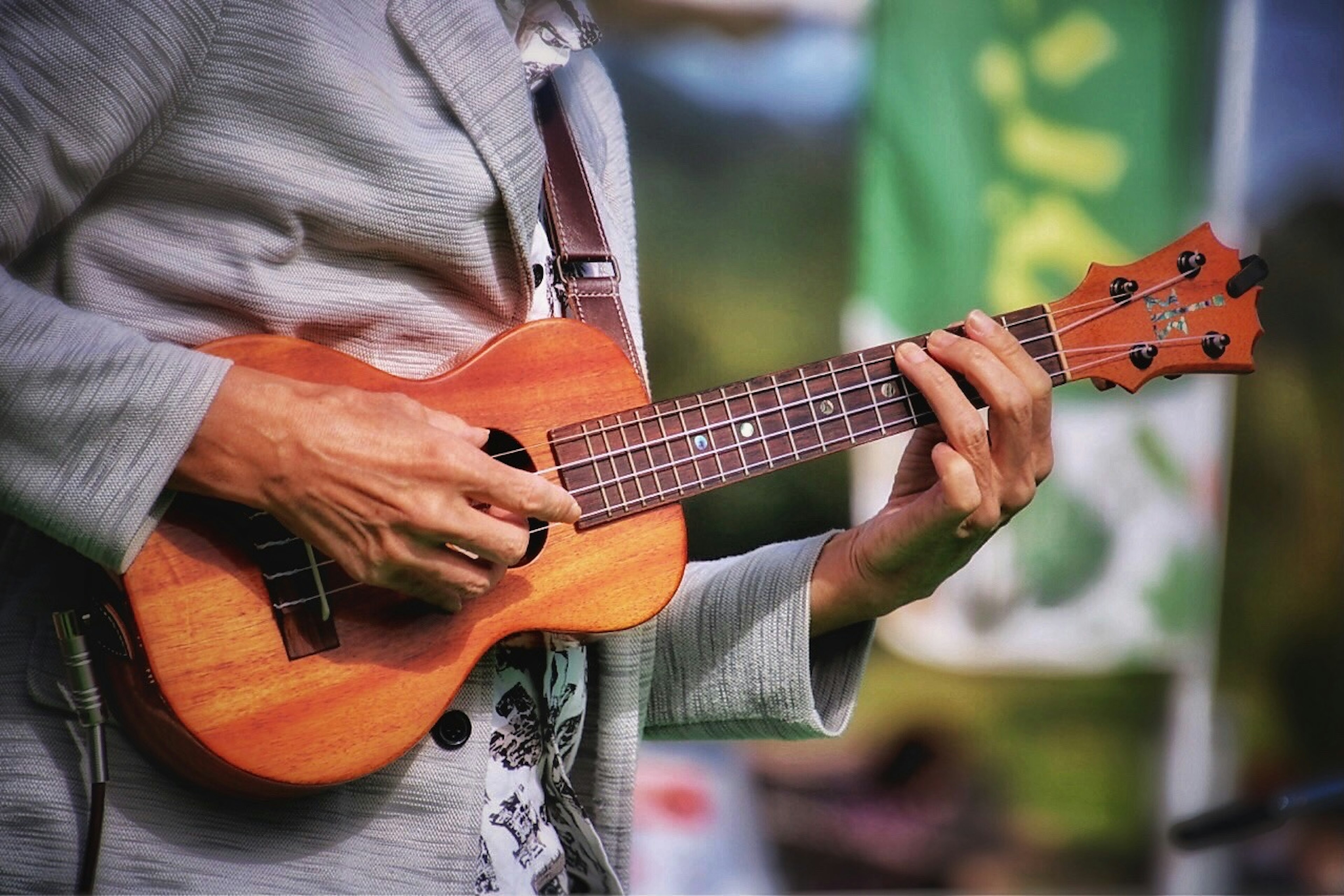 Hombre tocando un ukelele con detalles de madera