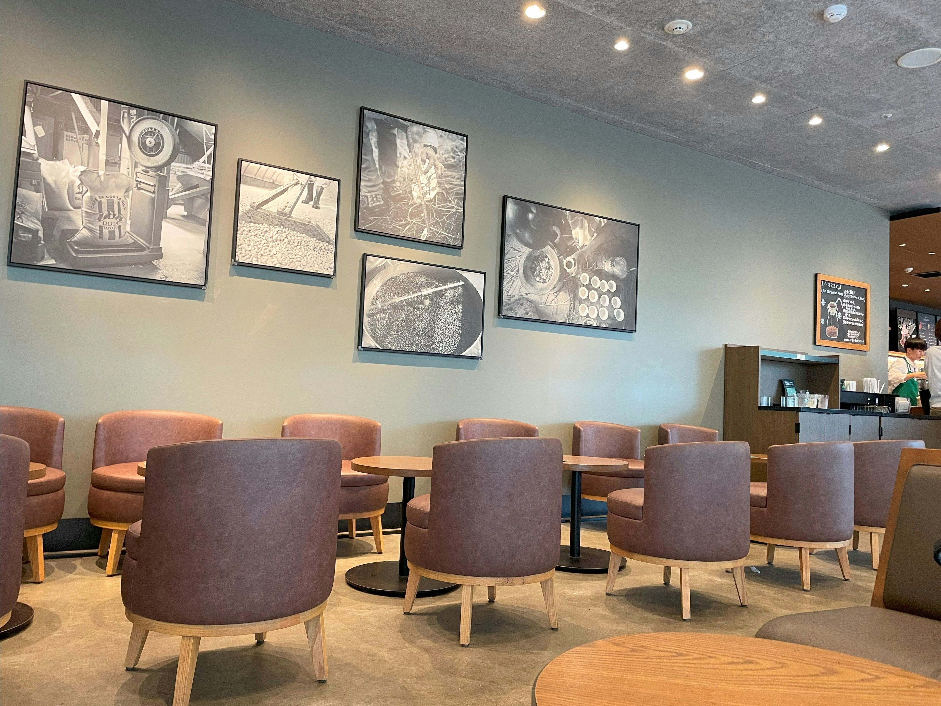 Cozy cafe interior featuring gray walls adorned with monochrome art pieces round tables and plush chairs