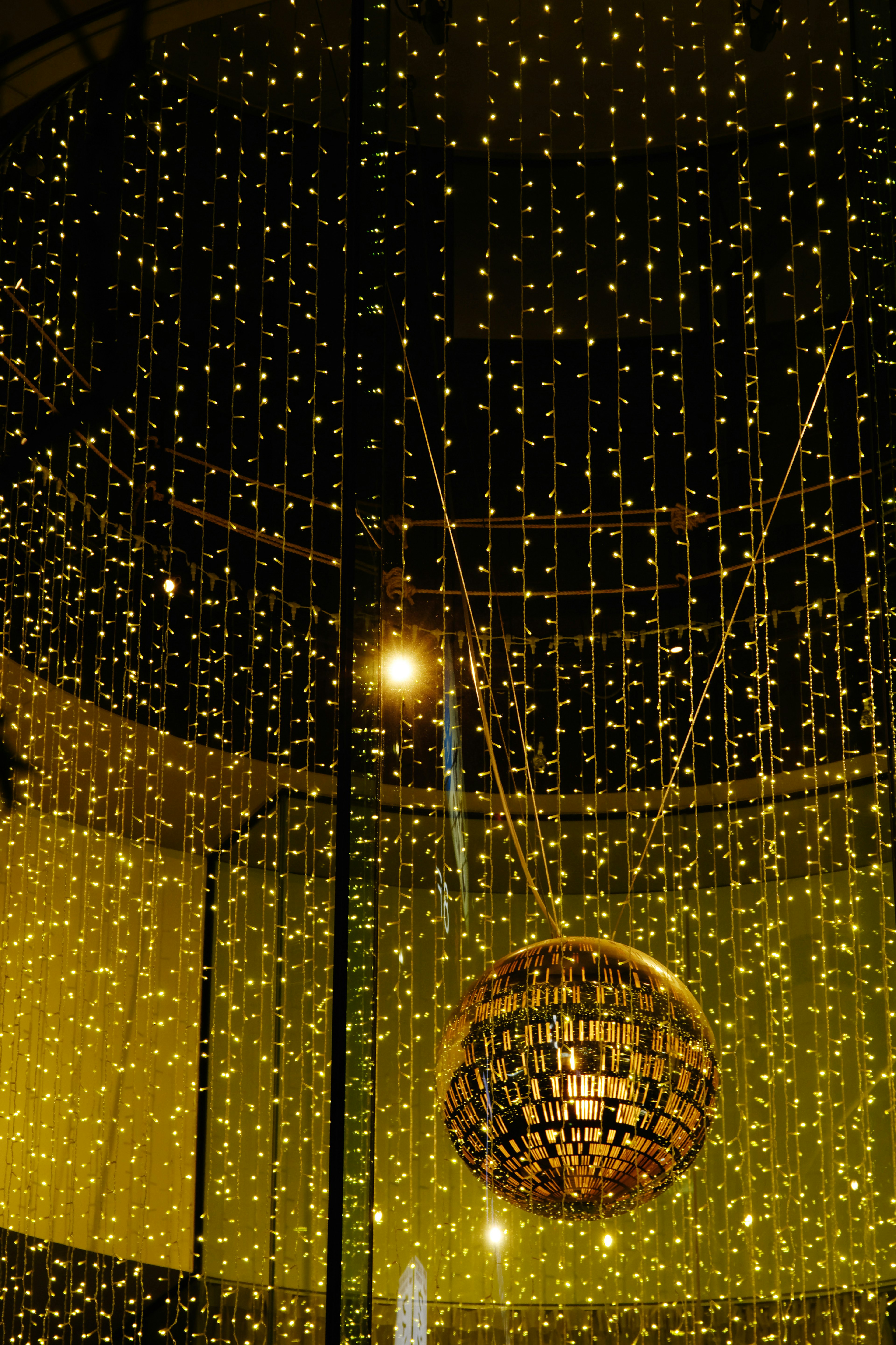 Imagen de un techo decorado con una esfera dorada y luces brillantes