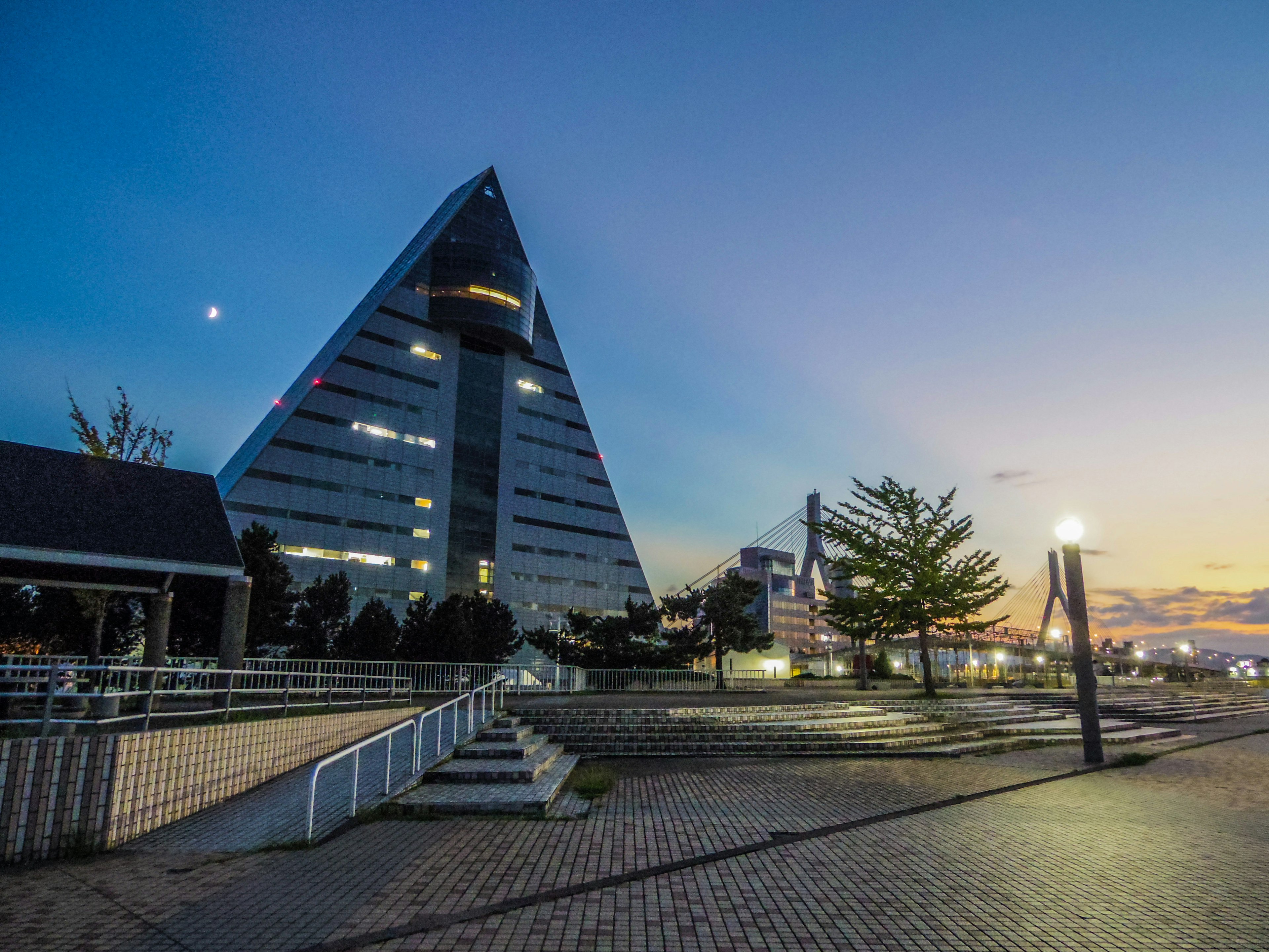 Edificio en forma de pirámide al atardecer con parque circundante