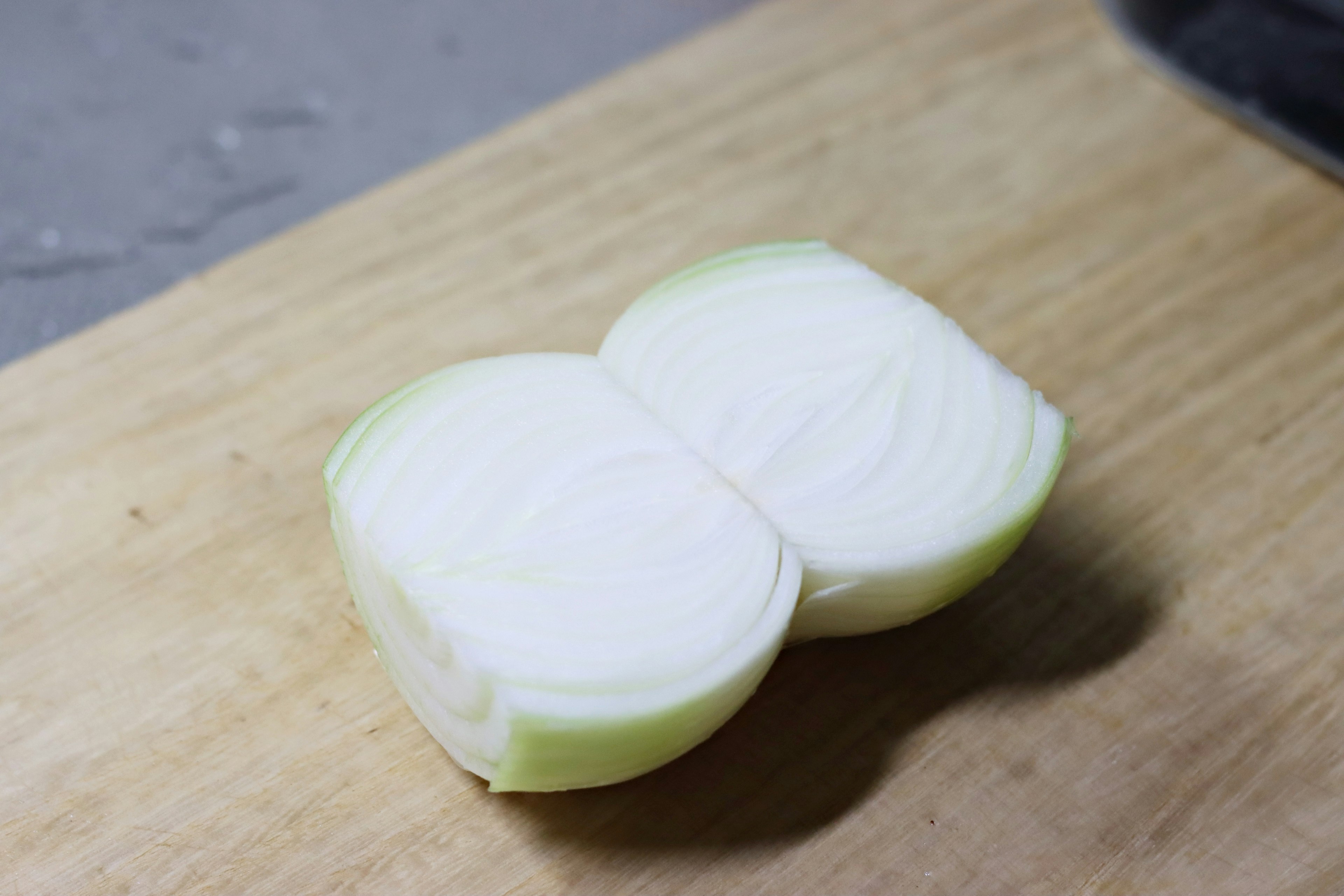 Mitad de una cebolla cortada sobre una tabla de madera