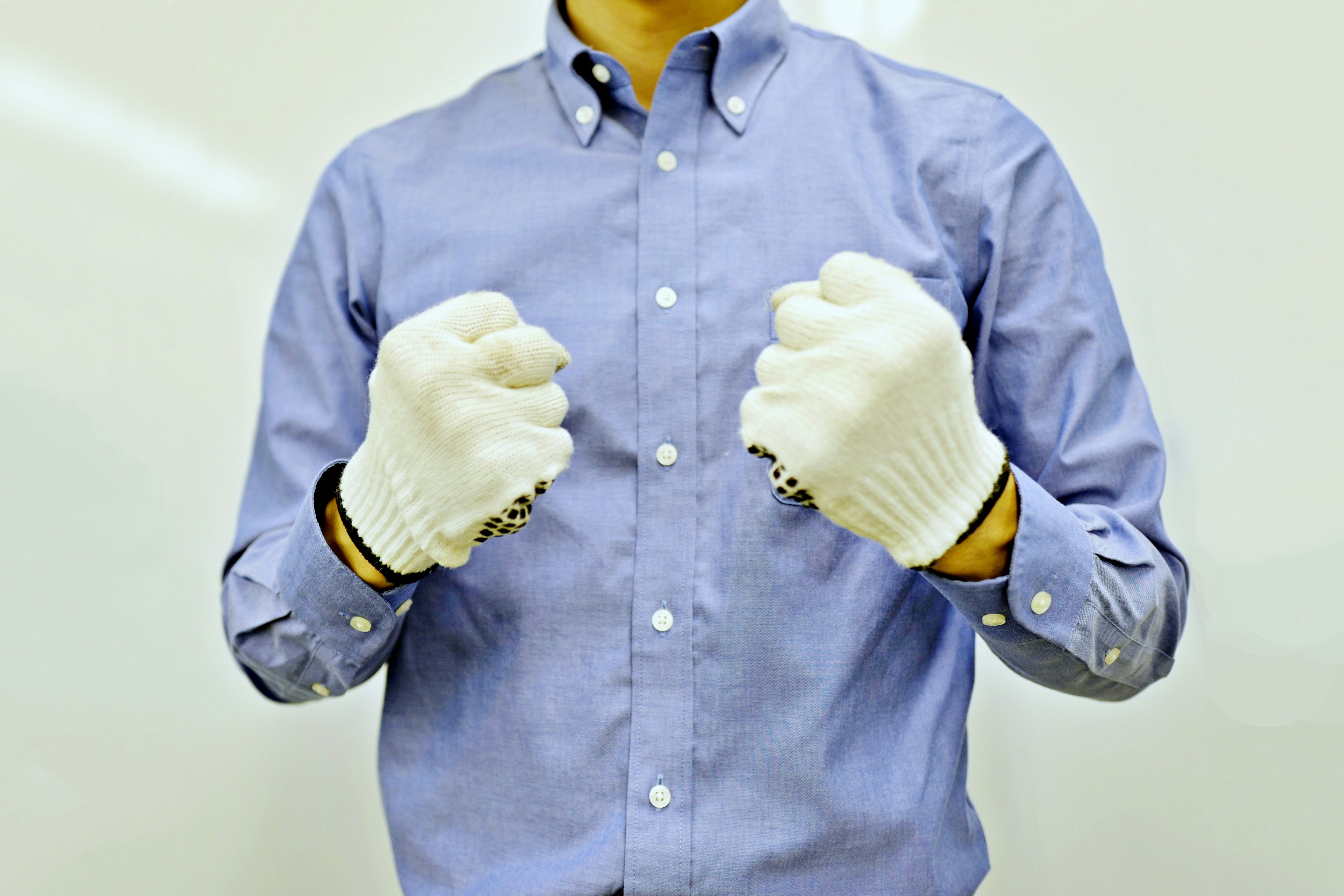 Un homme portant des gants blancs fait des poings