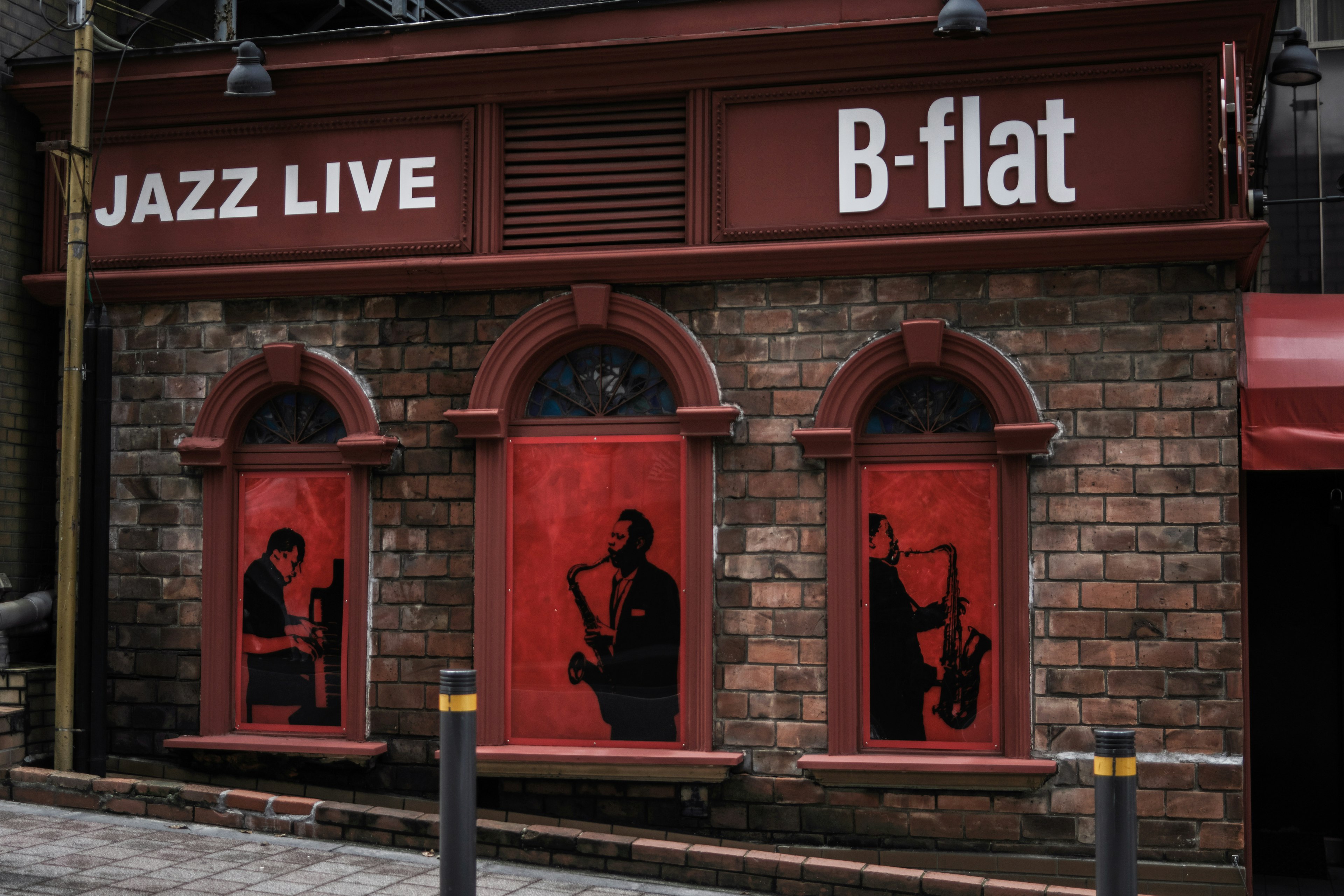 ด้านนอกของ B-flat พร้อมป้าย Jazz Live และเงาของนักดนตรี