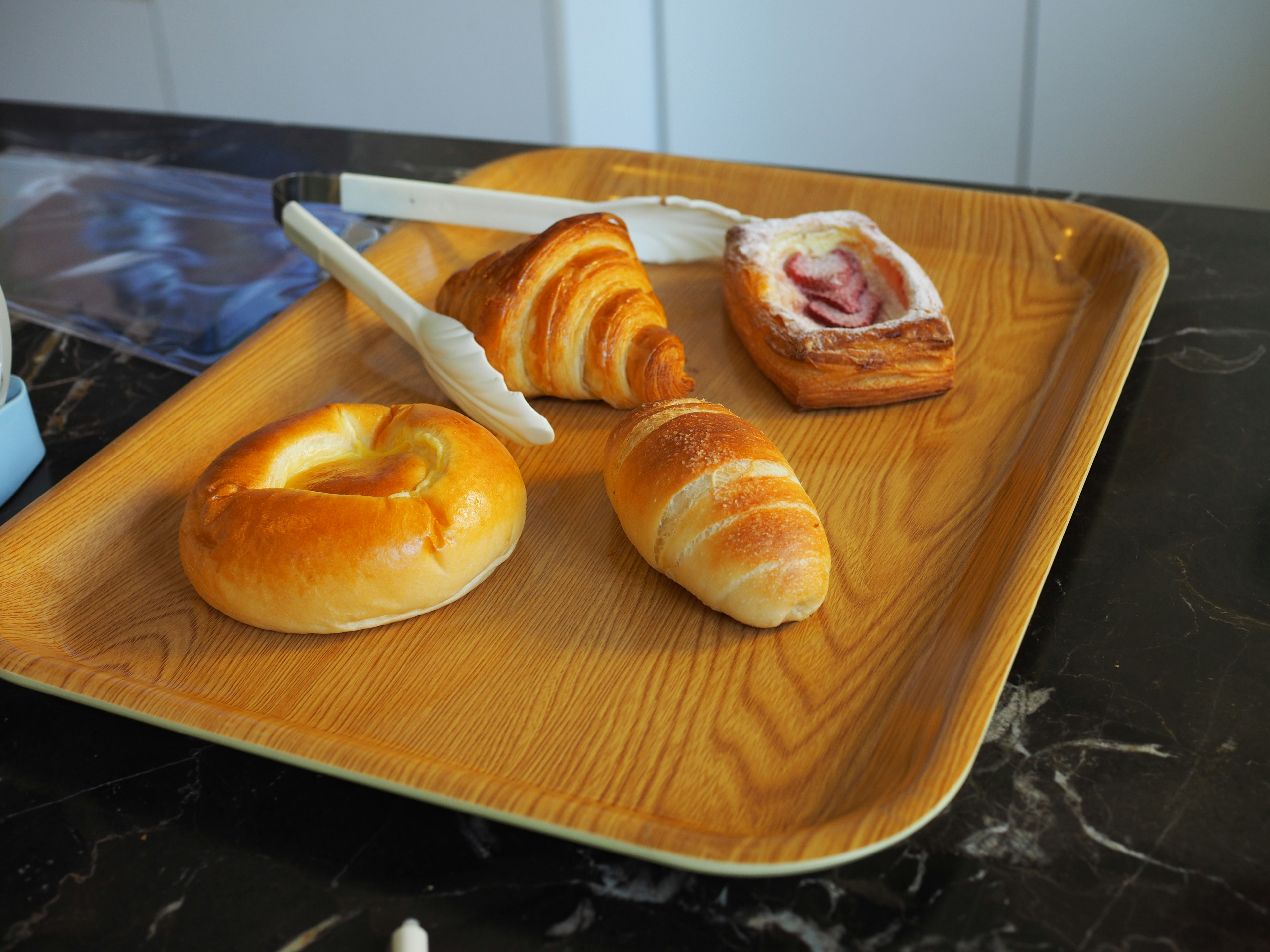 Assortimento di pasticcini e pane su un vassoio di legno