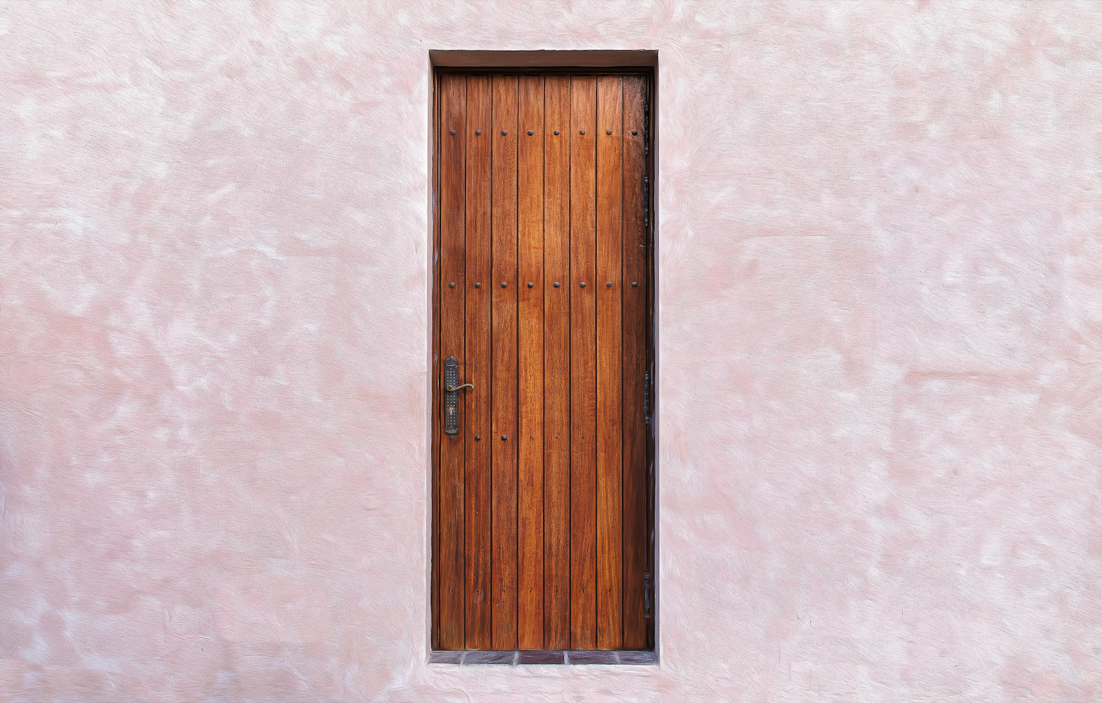 A wooden door mounted on a pink wall showcasing a simple and beautiful design