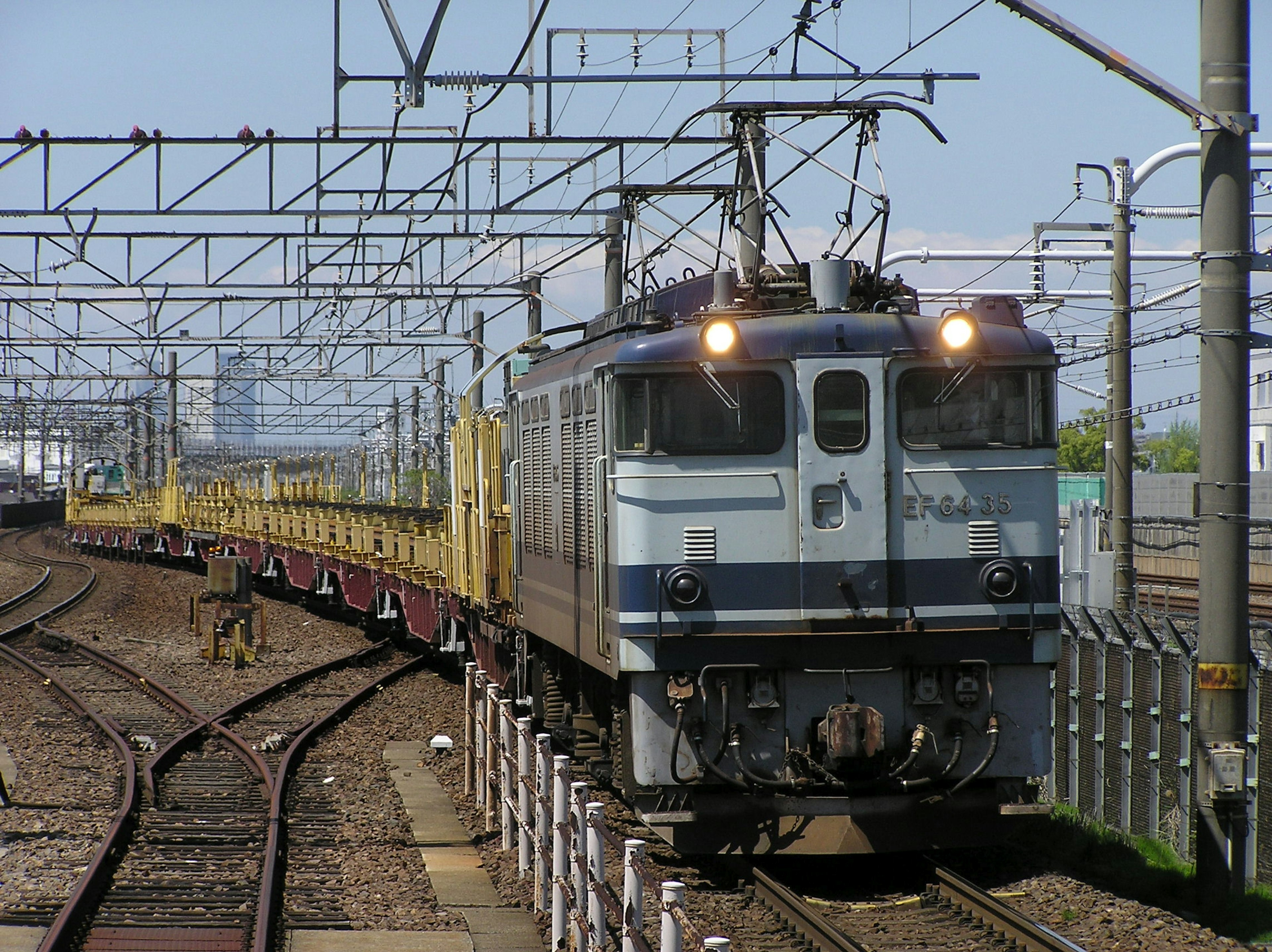 Locomotive électrique tirant un train de marchandises le long des rails