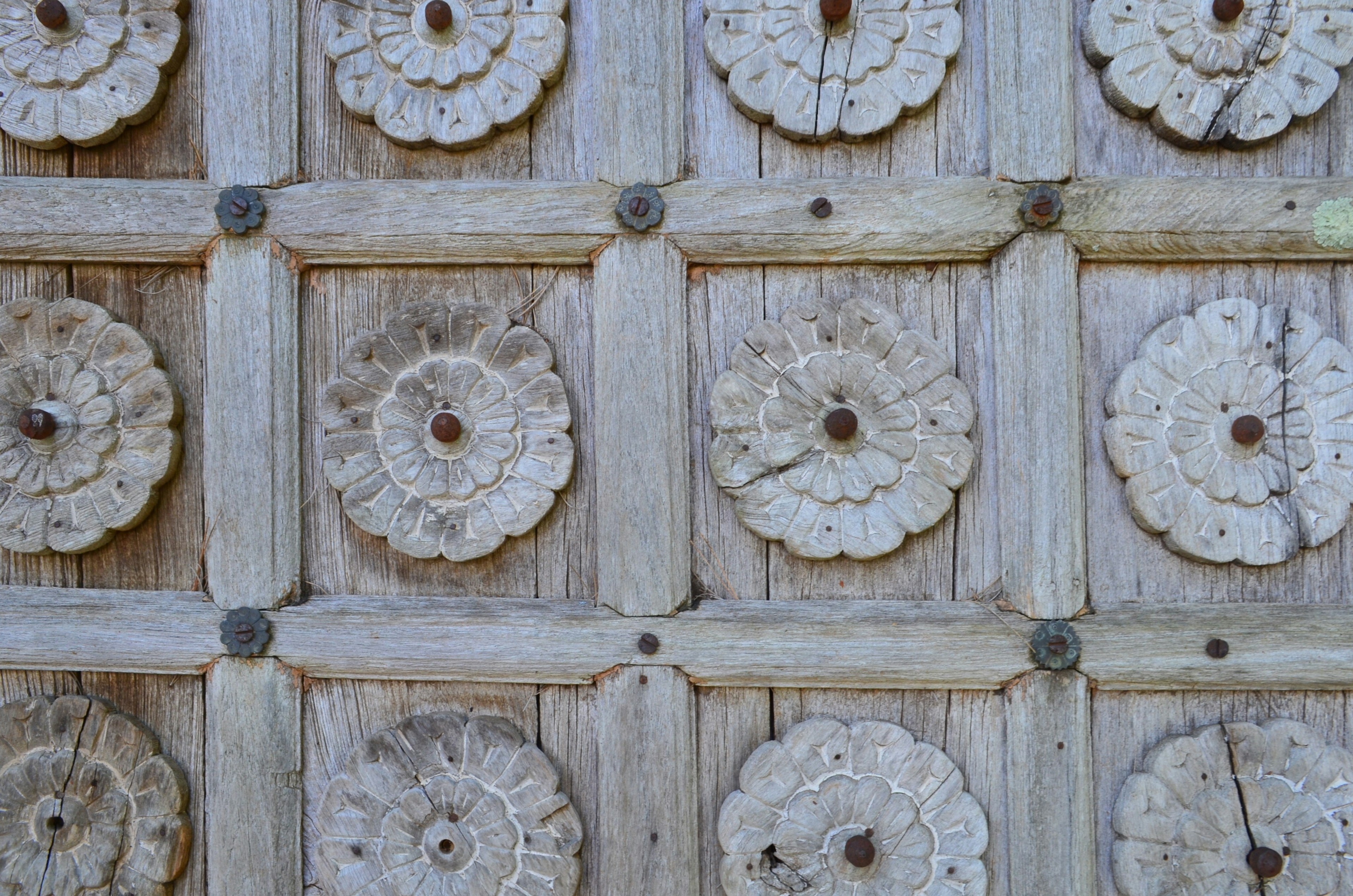 Schnitzereien von Blumenmotiven auf einer Holzwand angeordnet