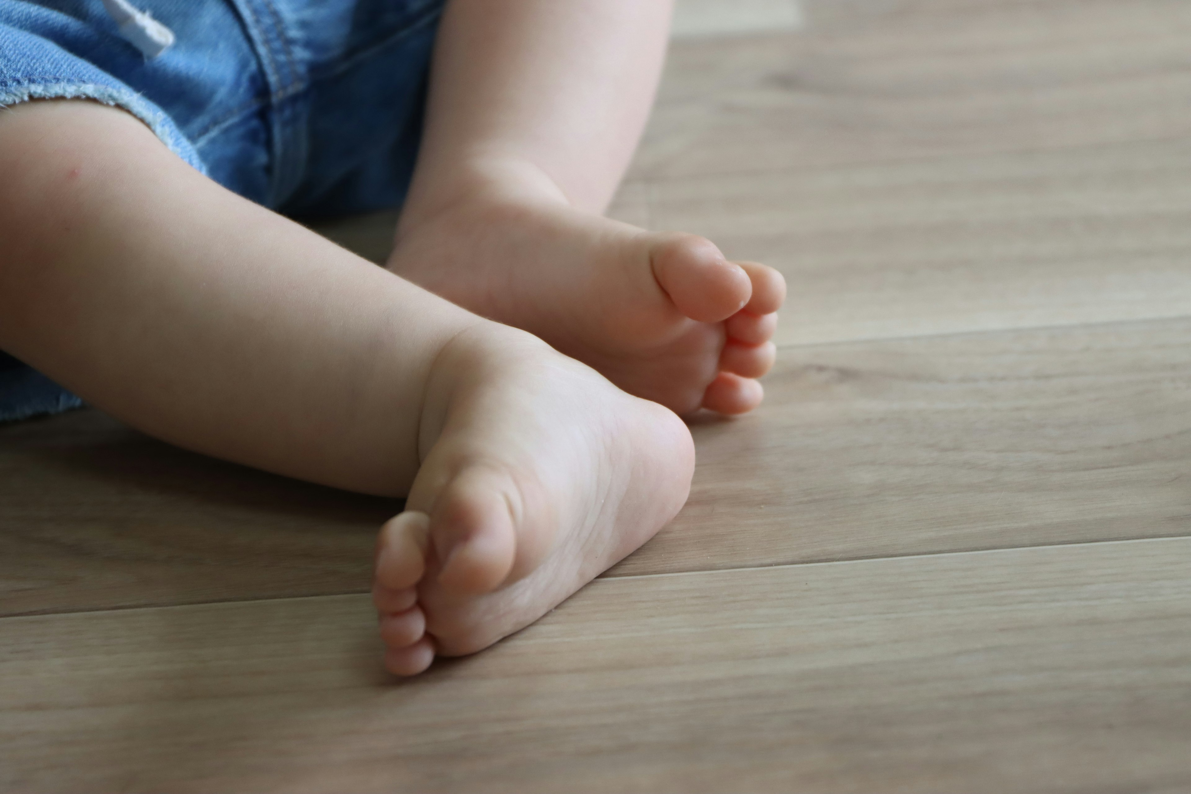 Baby feet resting on wooden floor