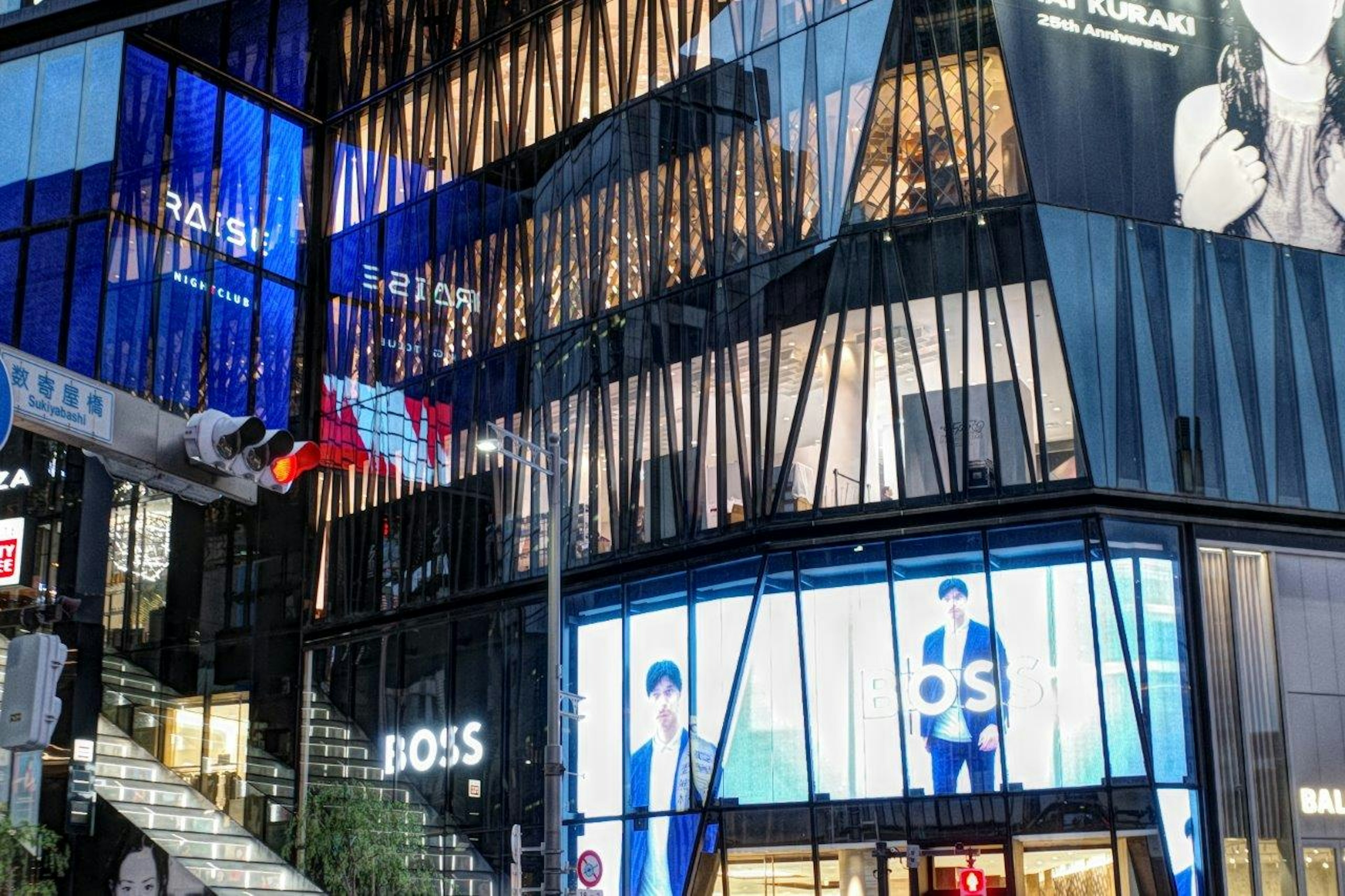 Modern building exterior with bright advertisements in a night cityscape