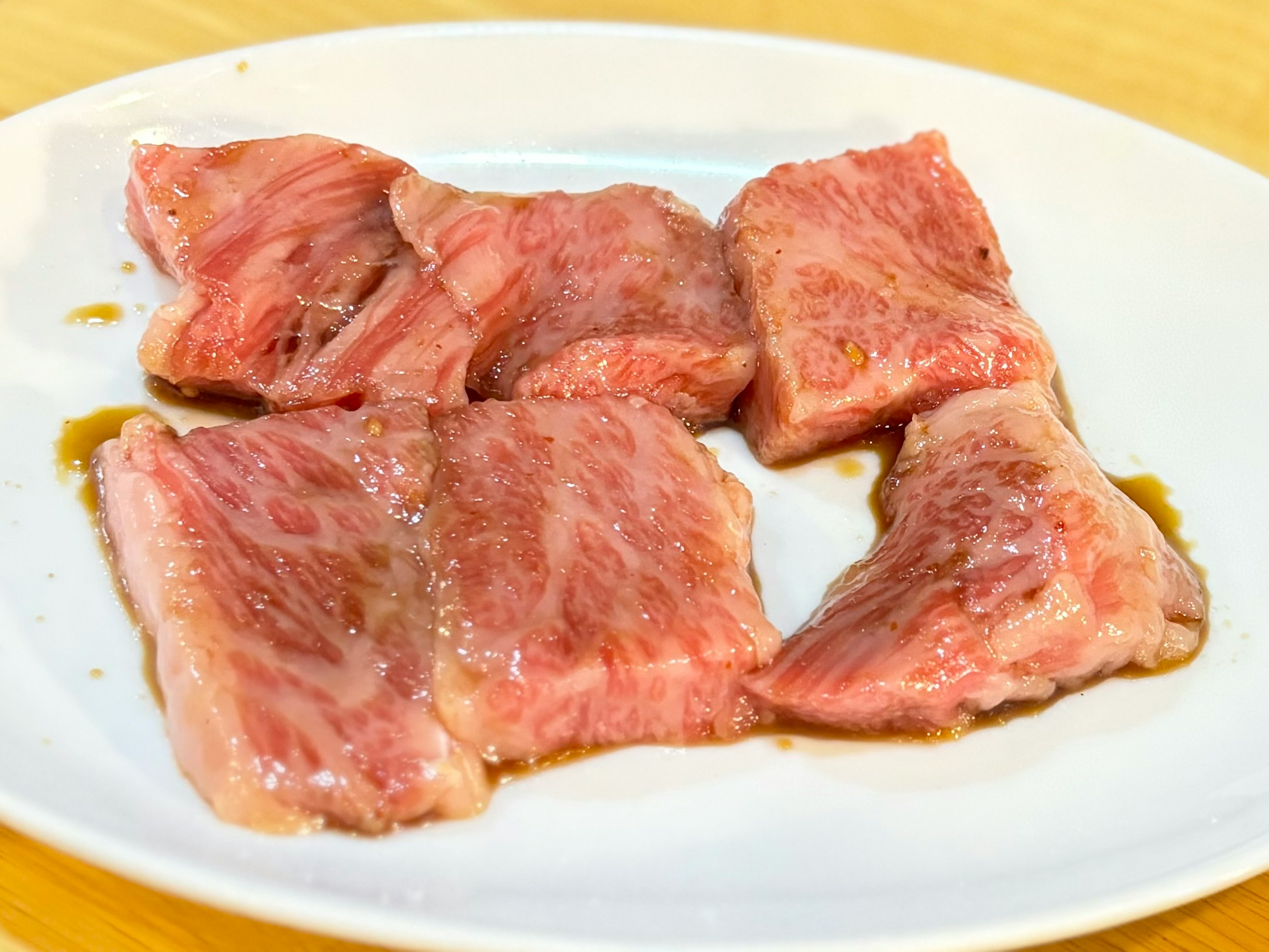 Morceaux de viande tranchés disposés sur une assiette blanche