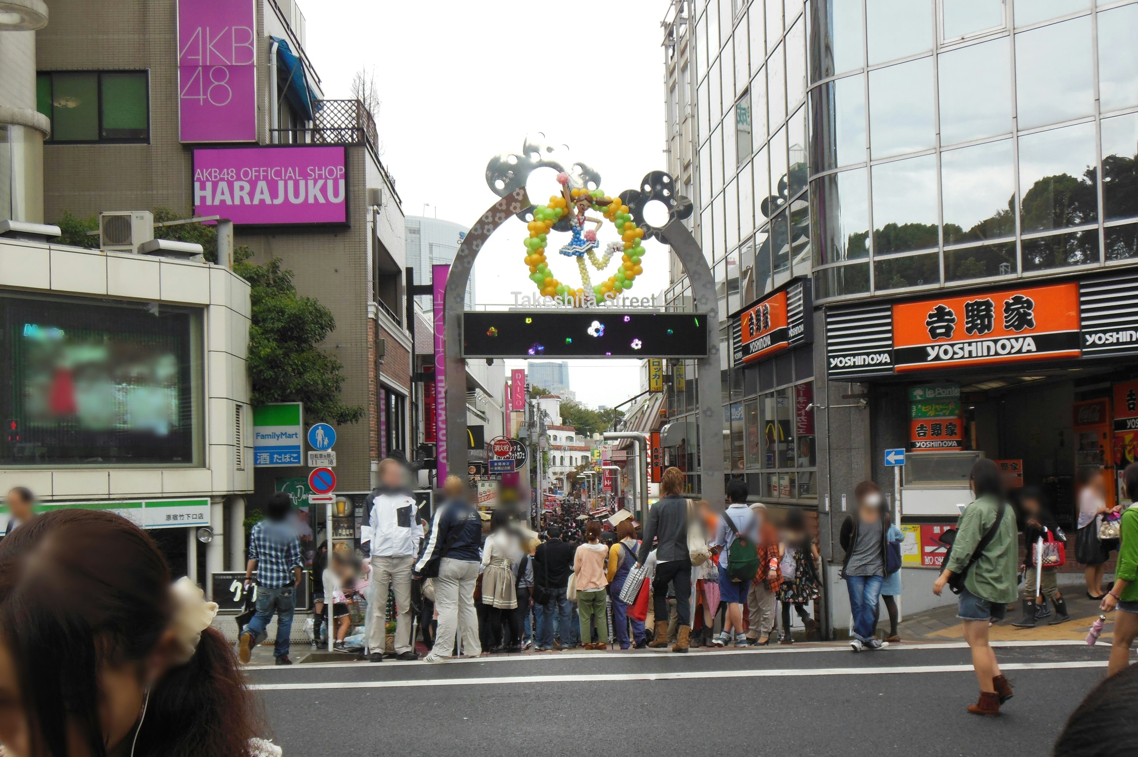 Colorful archway on a busy street in Harajuku with crowds of people