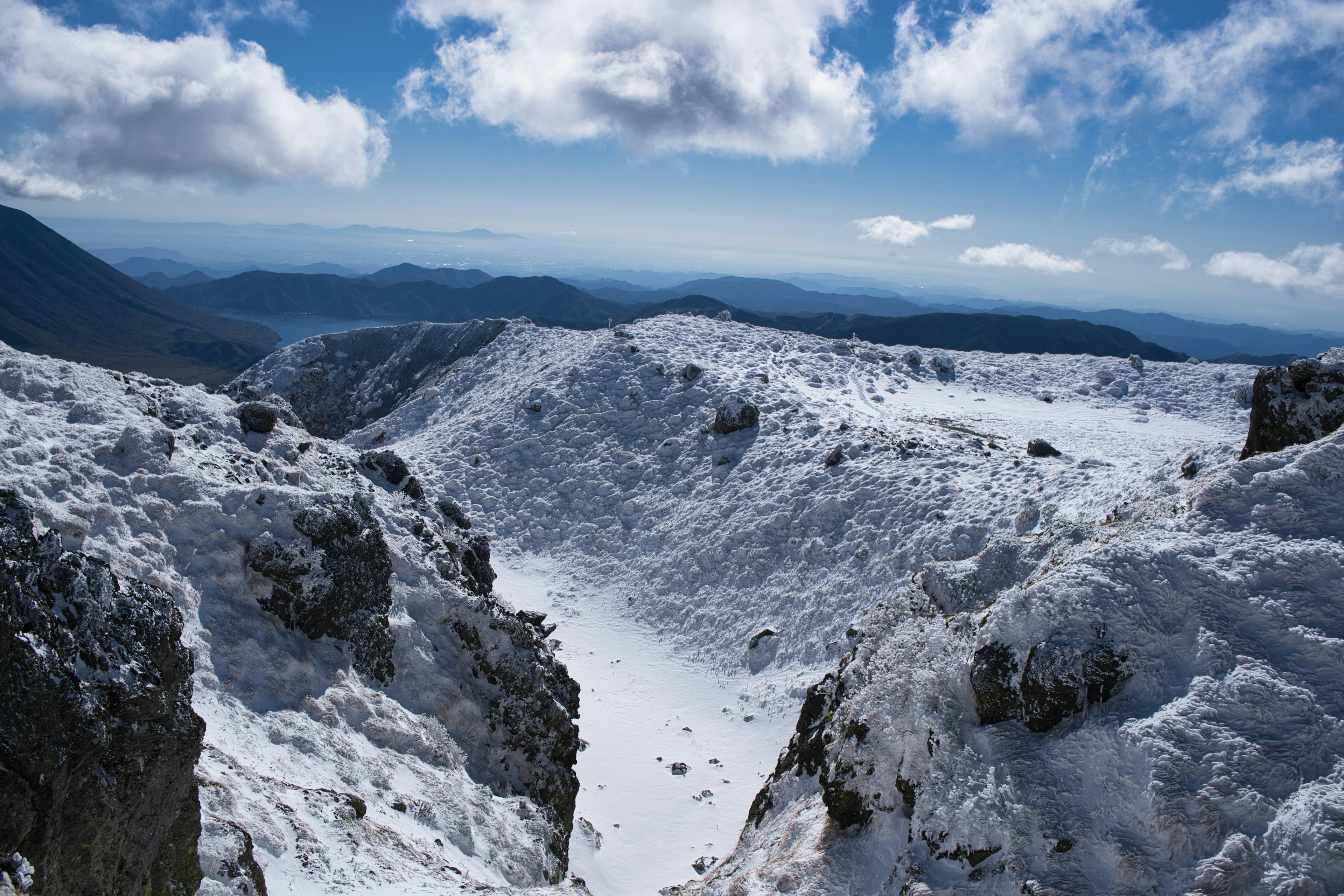 Schneebedecktes Bergtal mit blauem Himmel