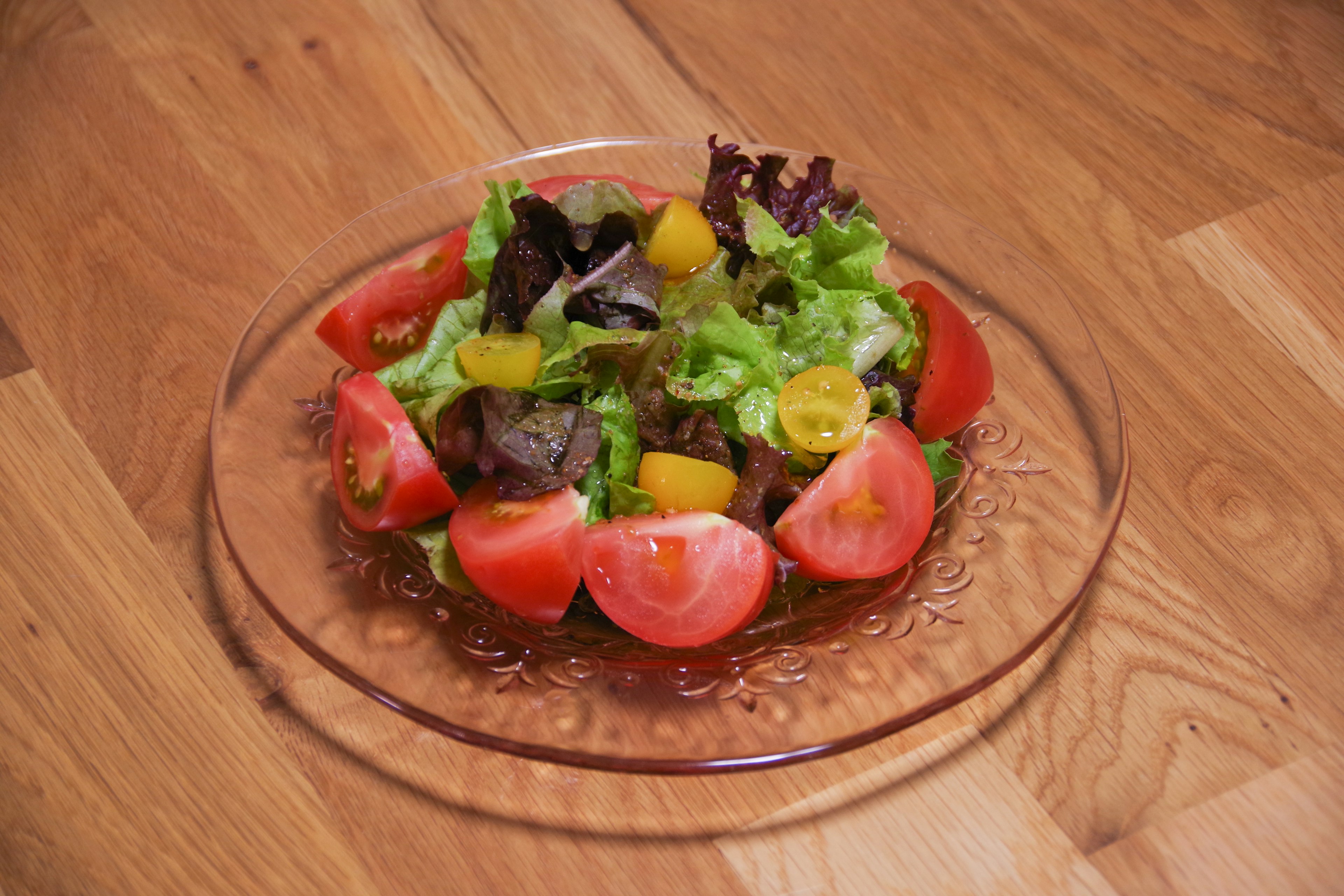 Insalata di verdure colorate servita su un piatto trasparente