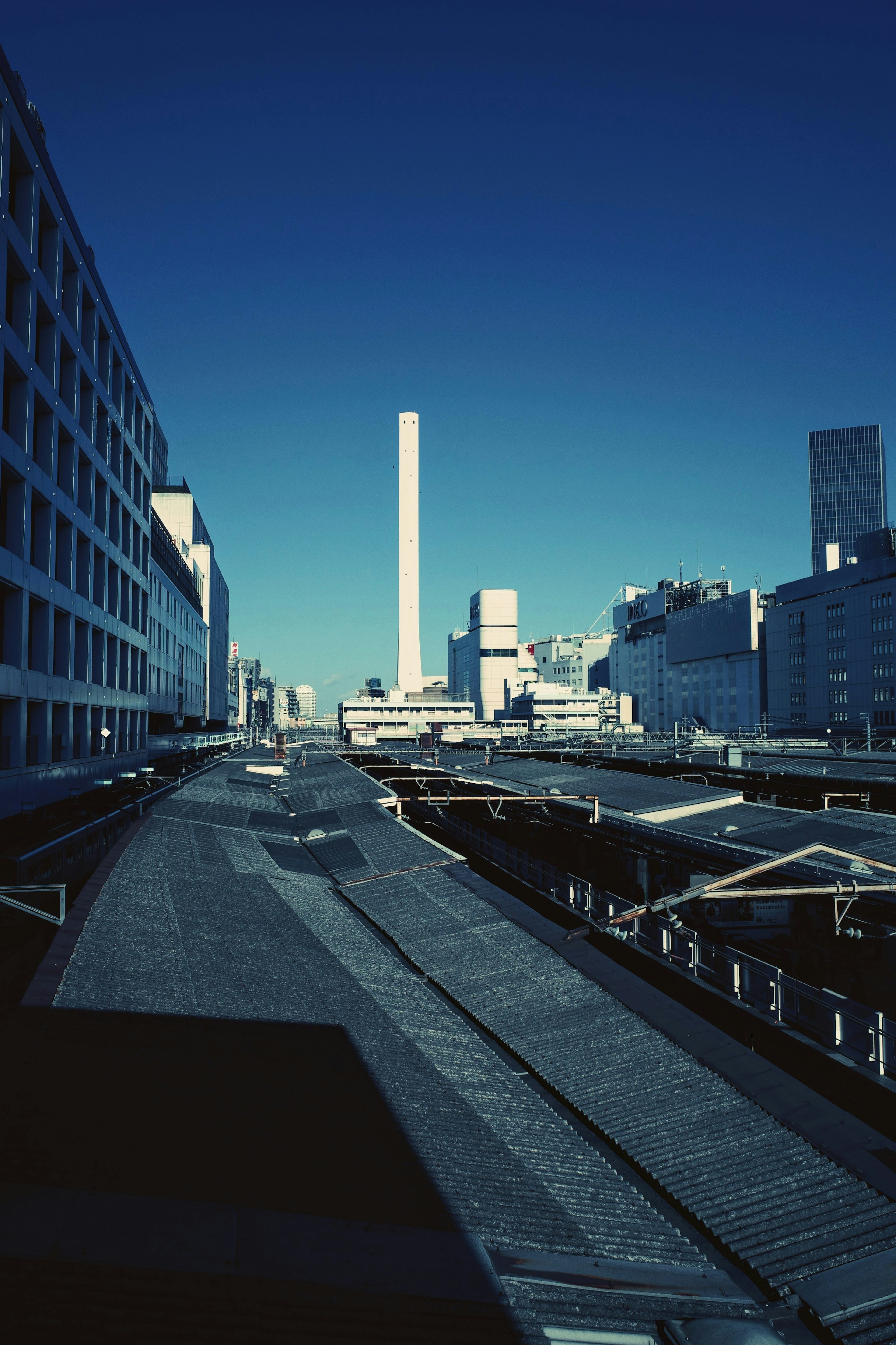 青空の下に高い煙突と近代的な建物の風景