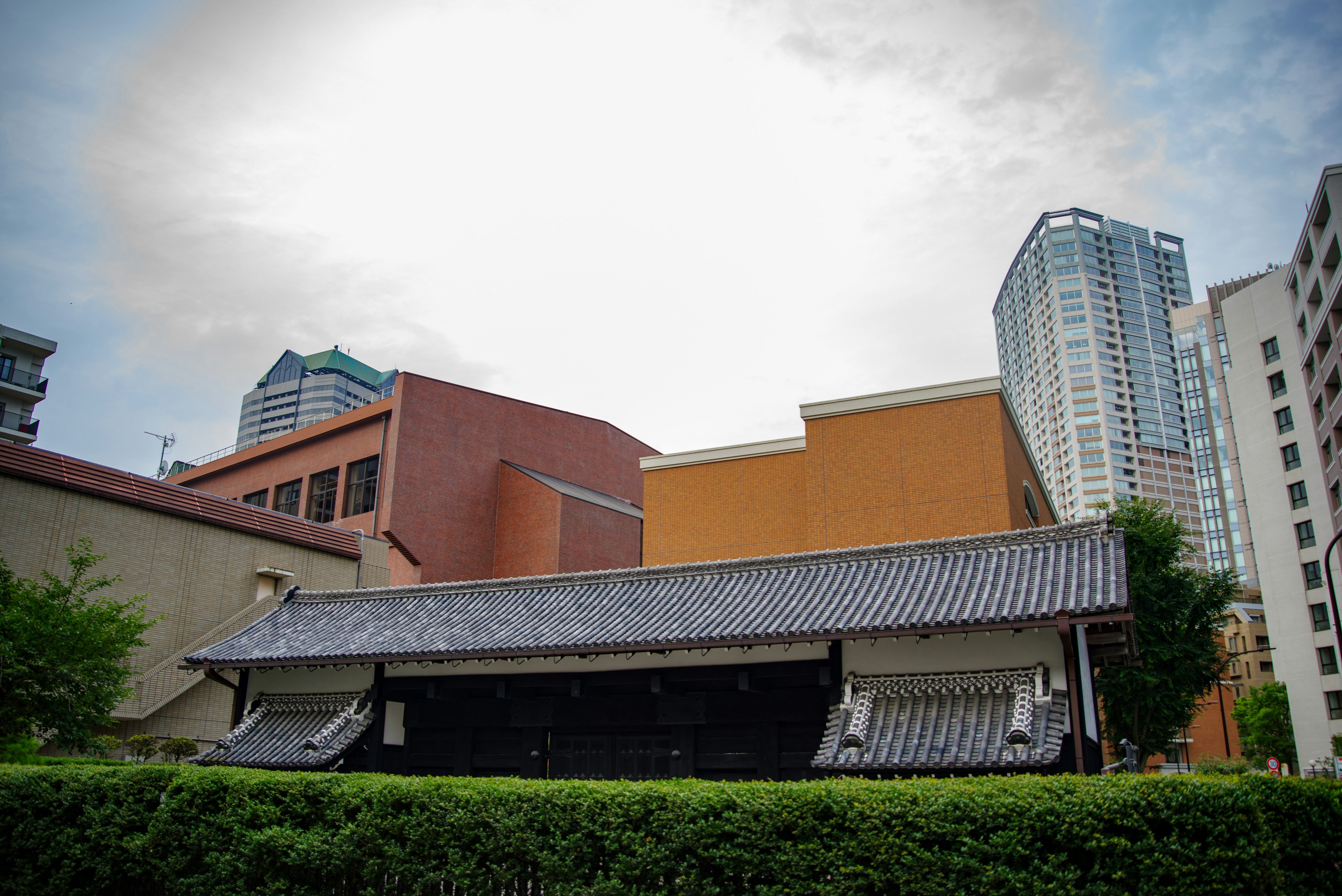 Ein Kontrast zwischen modernen Wolkenkratzern und einem traditionellen japanischen Gebäude