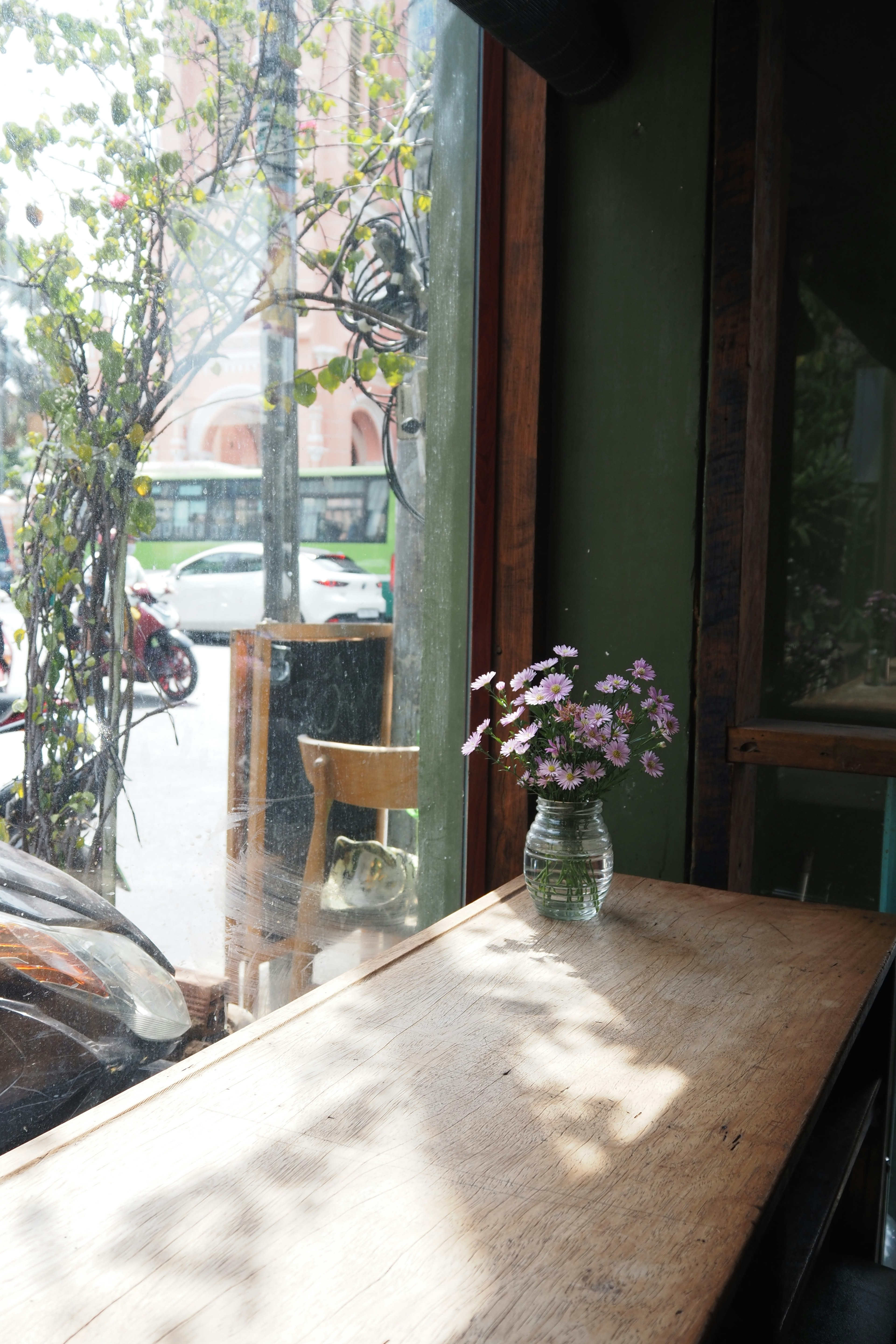 Intérieur d'un café avec une table et un vase de fleurs près de la fenêtre