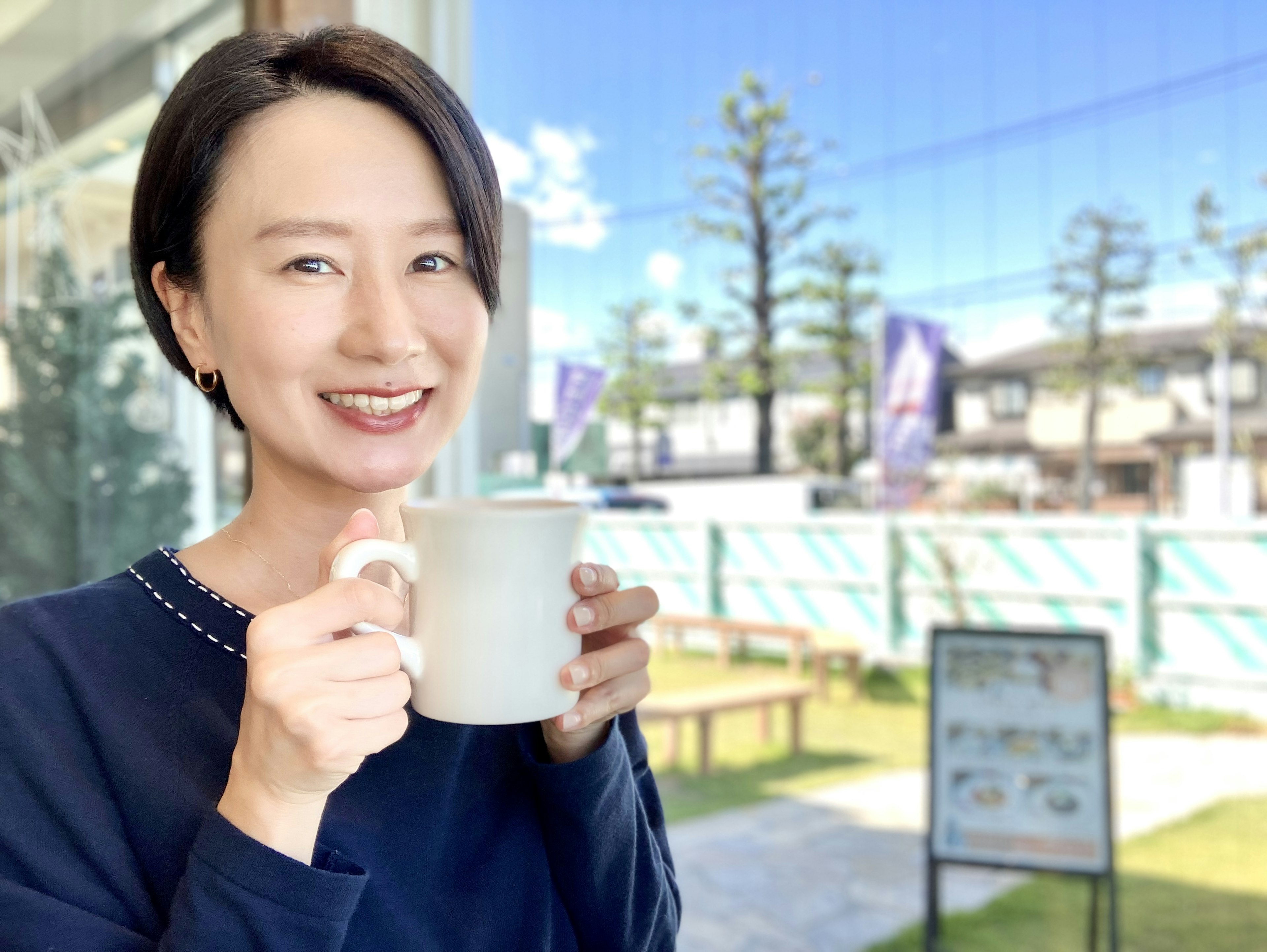 Mujer sonriente sosteniendo una taza de café en una cafetería