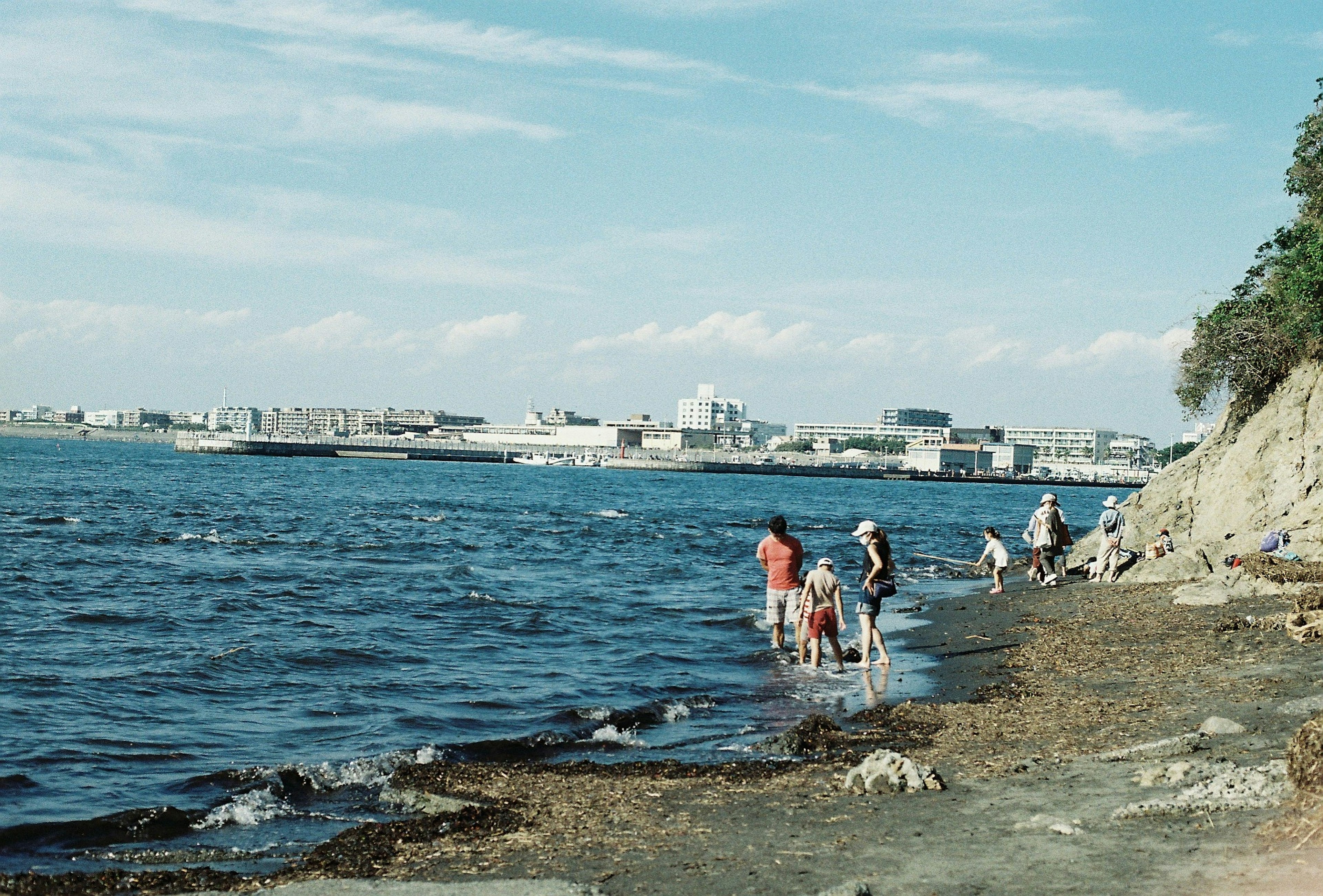 海辺で遊ぶ人々と青い空