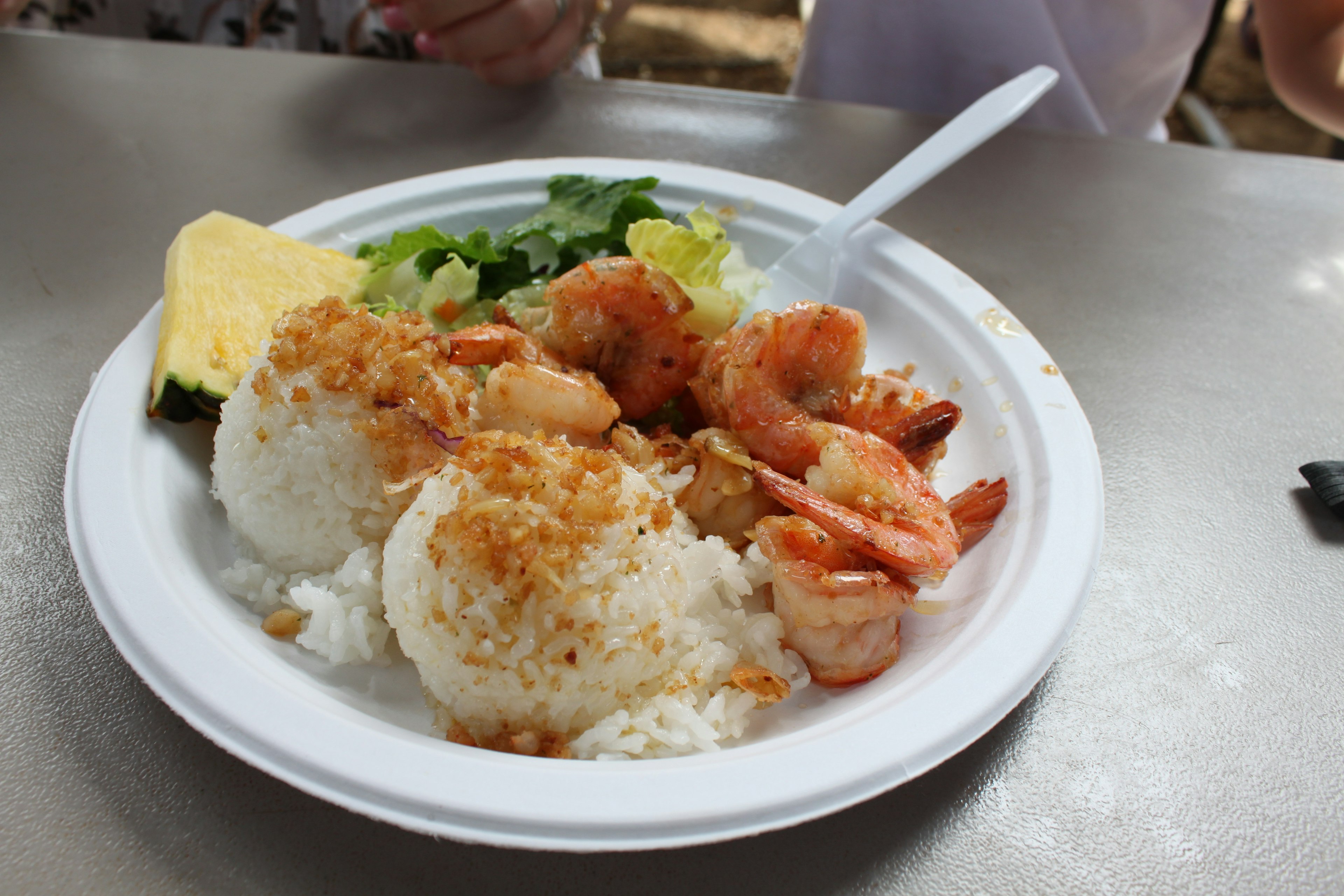 Plato de camarones con arroz ensalada y una rodaja de piña