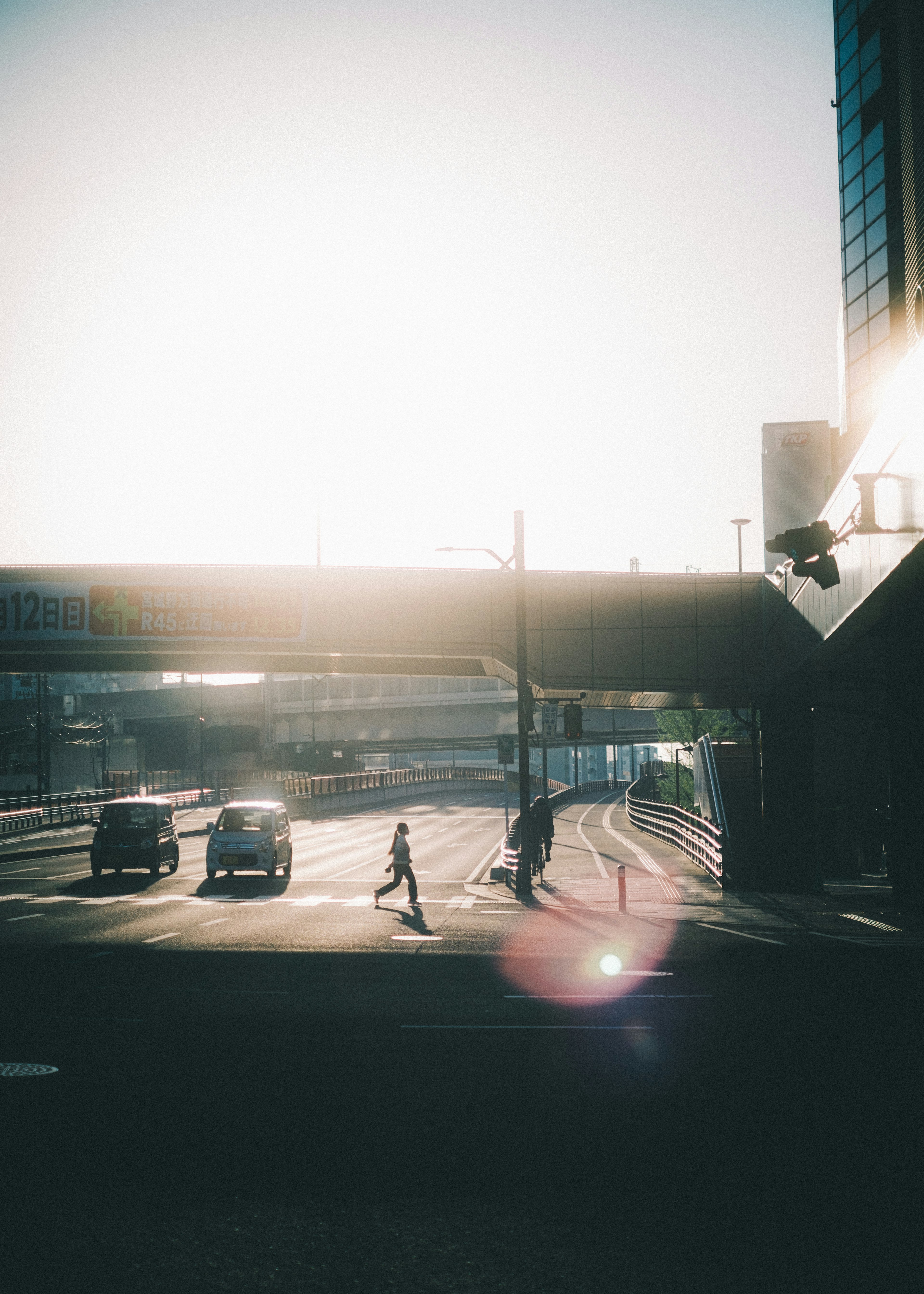 Silhouetten von Personen und Autos, die im Gegenlicht gehen