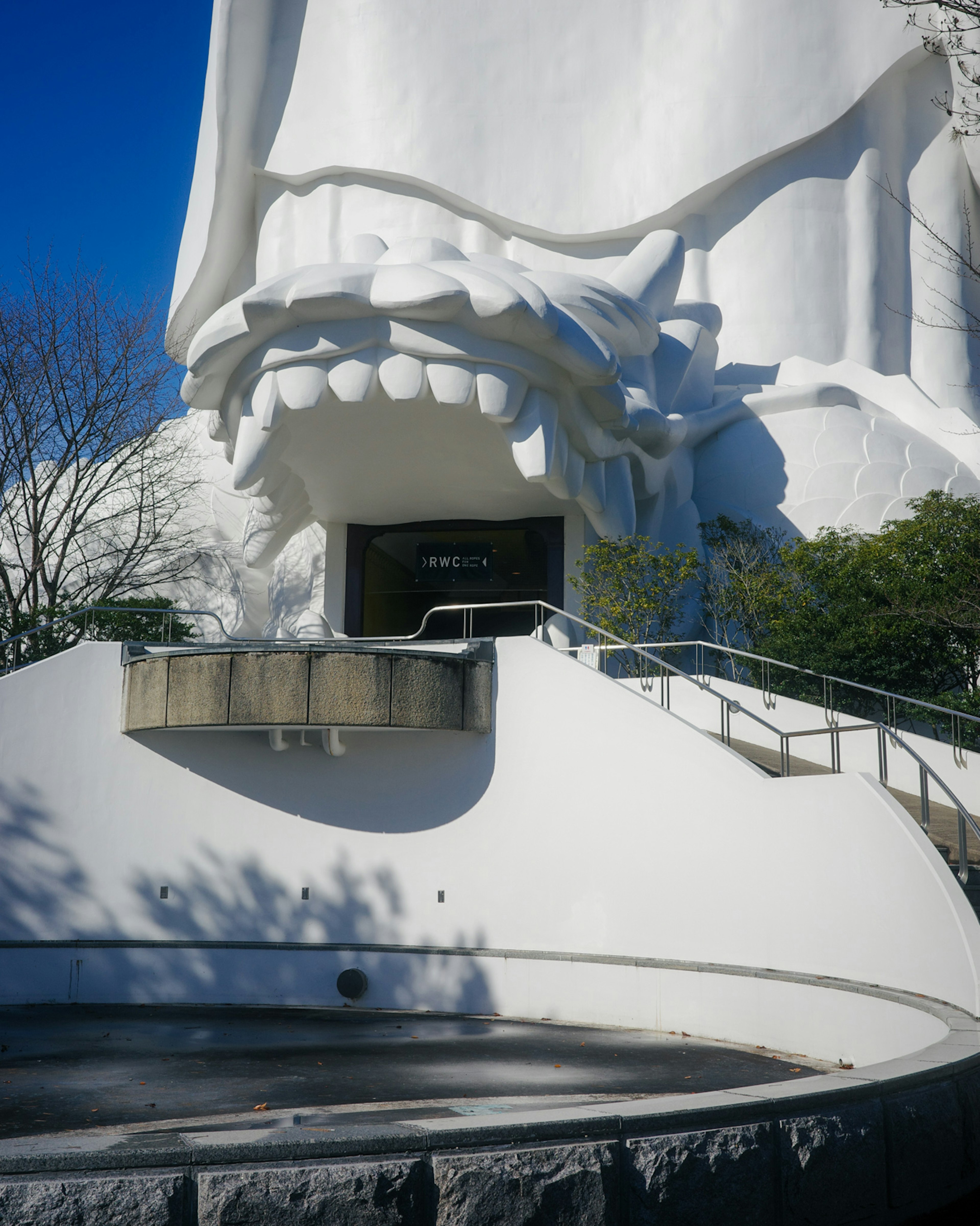 Entrada imponente con la boca de una gran estatua blanca