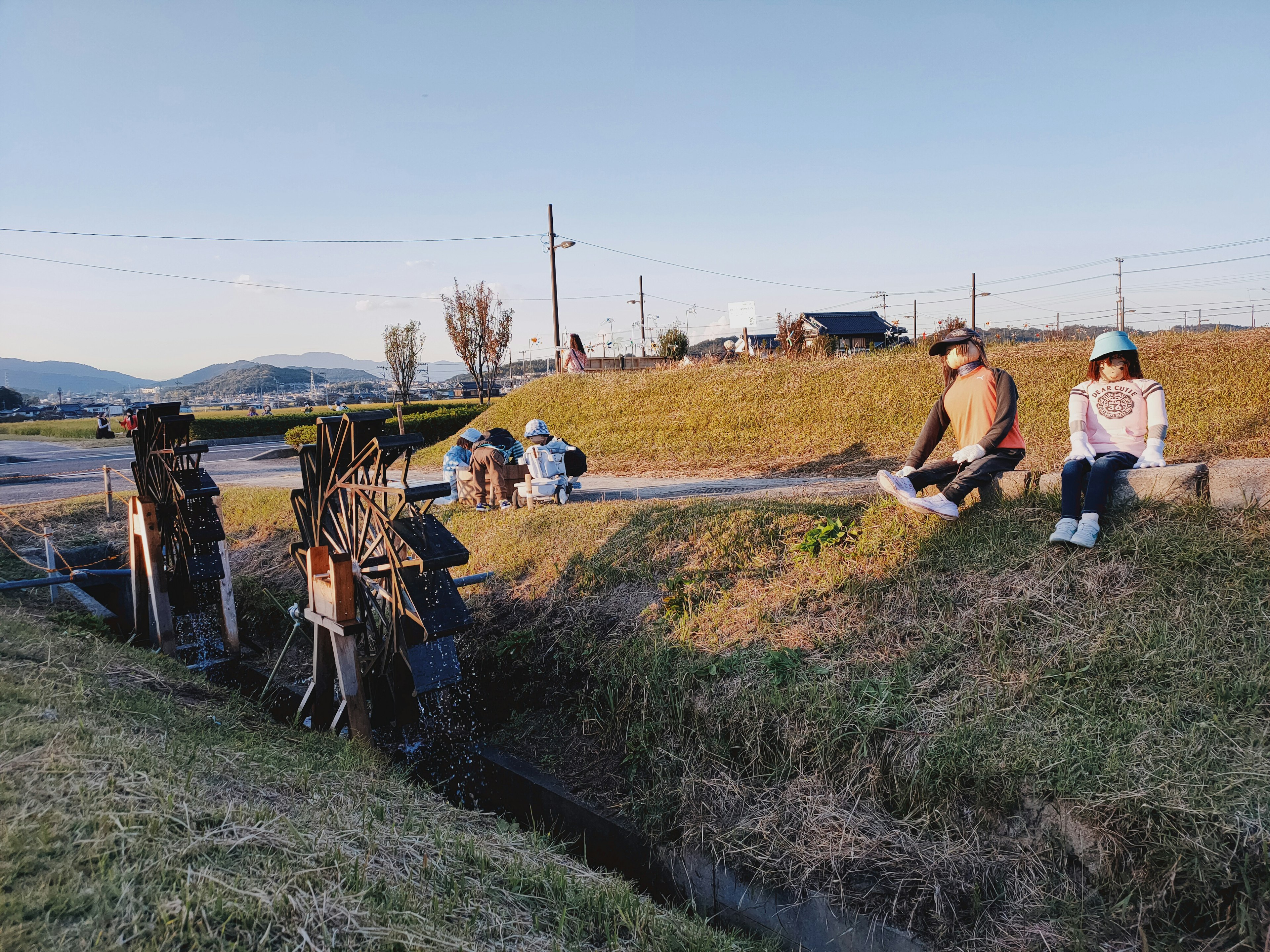 Des personnes se détendant près d'un paysage rural avec un ruisseau