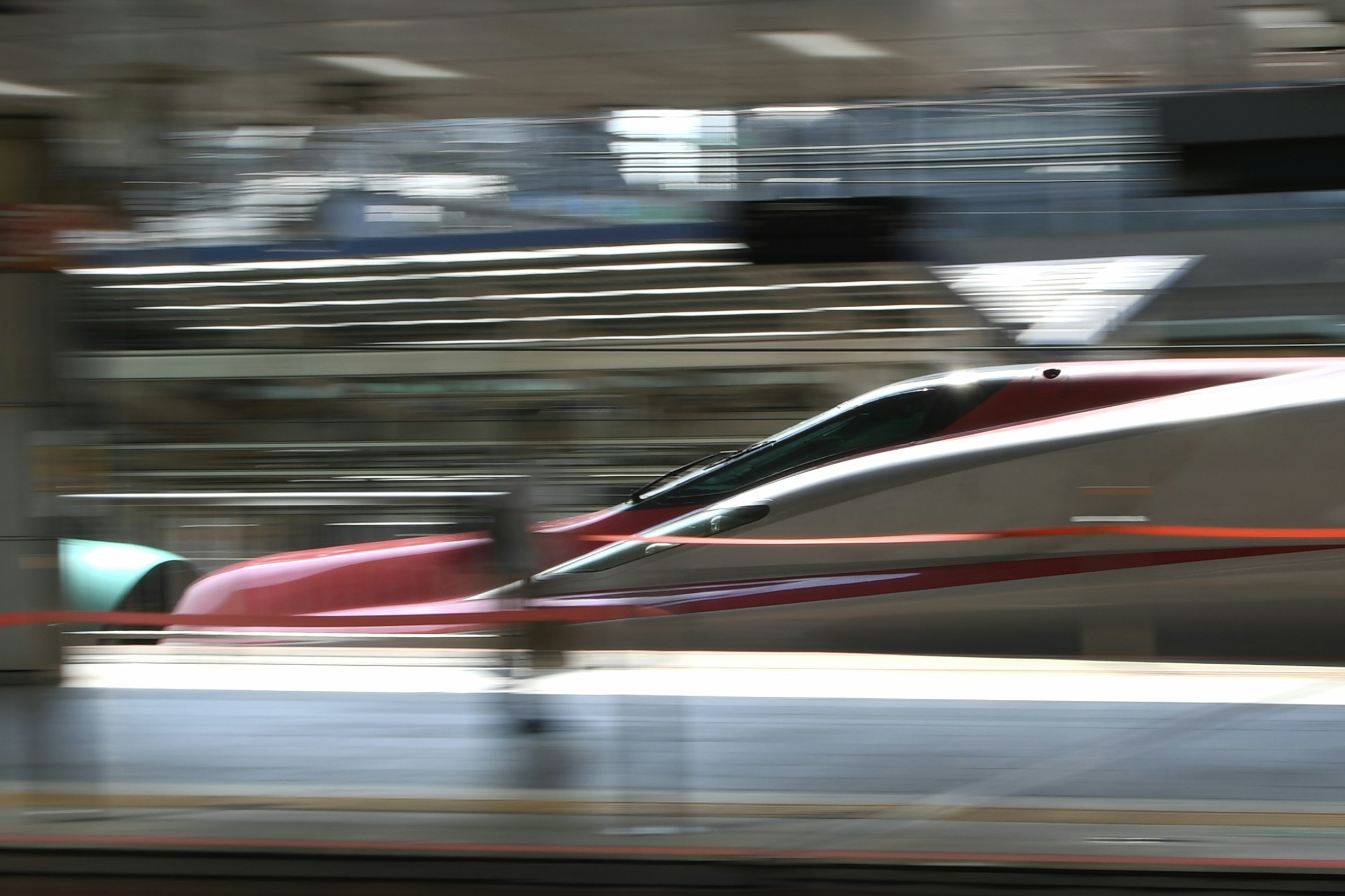 Shinkansen passant par une gare avec flou de mouvement