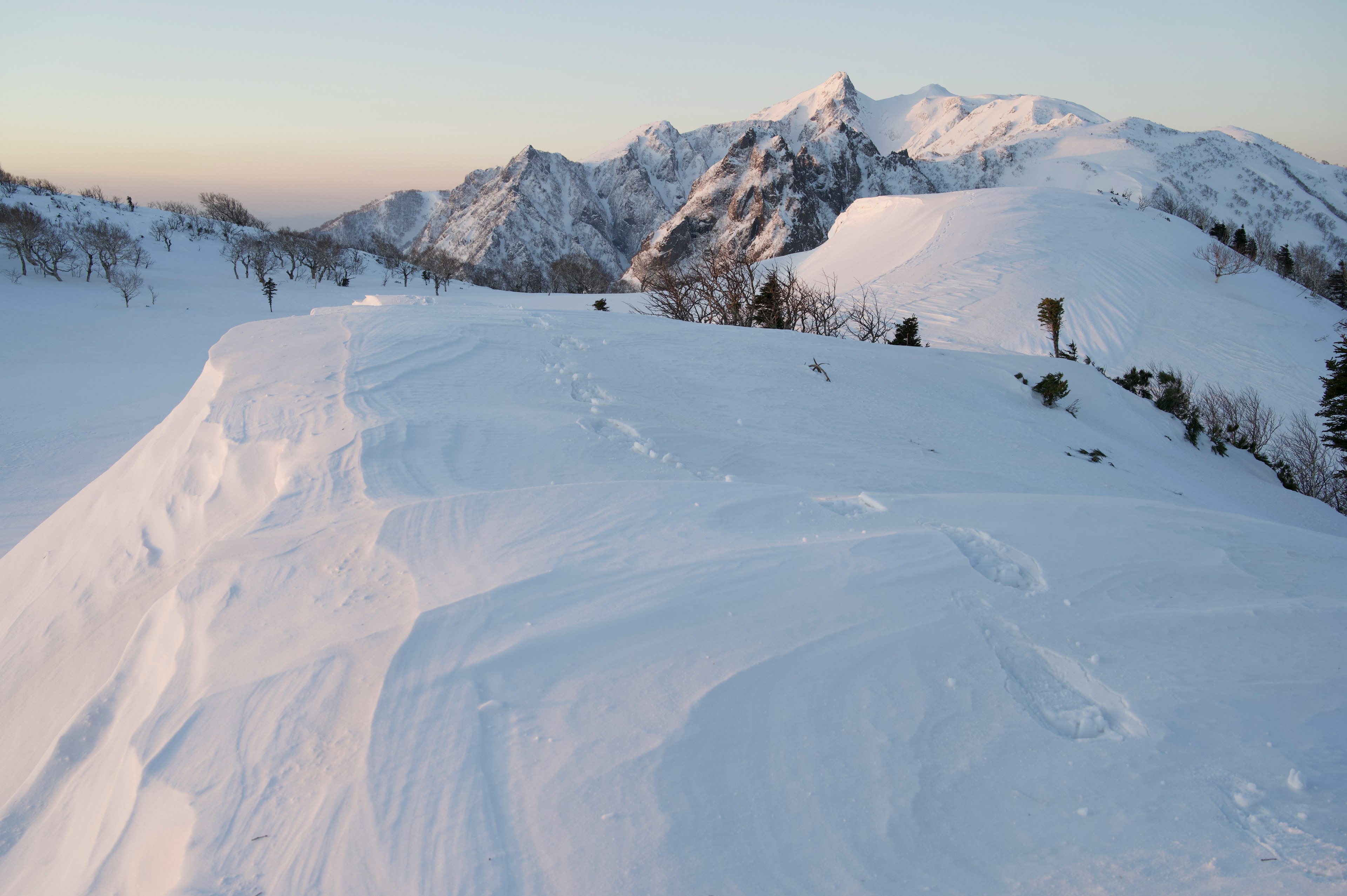 Paesaggio montano coperto di neve con colline di neve lisce