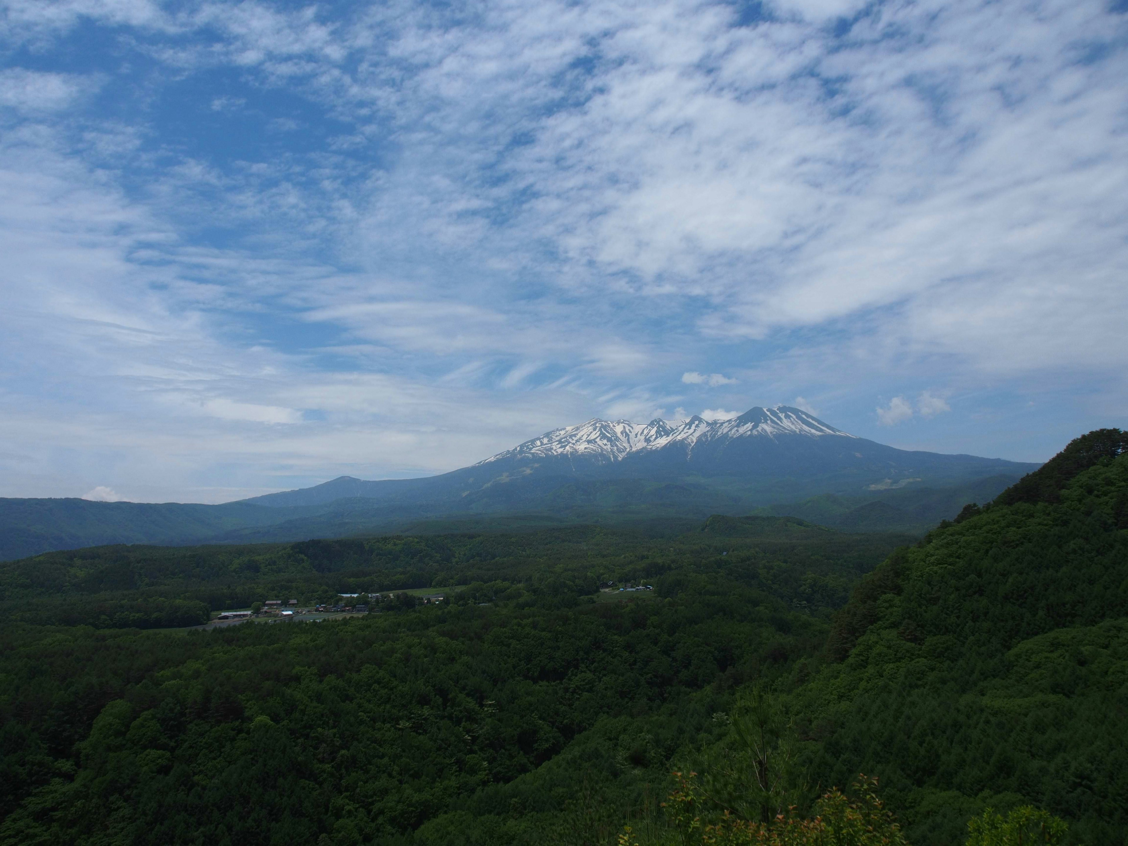 Scenic mountain landscape with snow-capped peaks and blue sky lush green forests and valleys