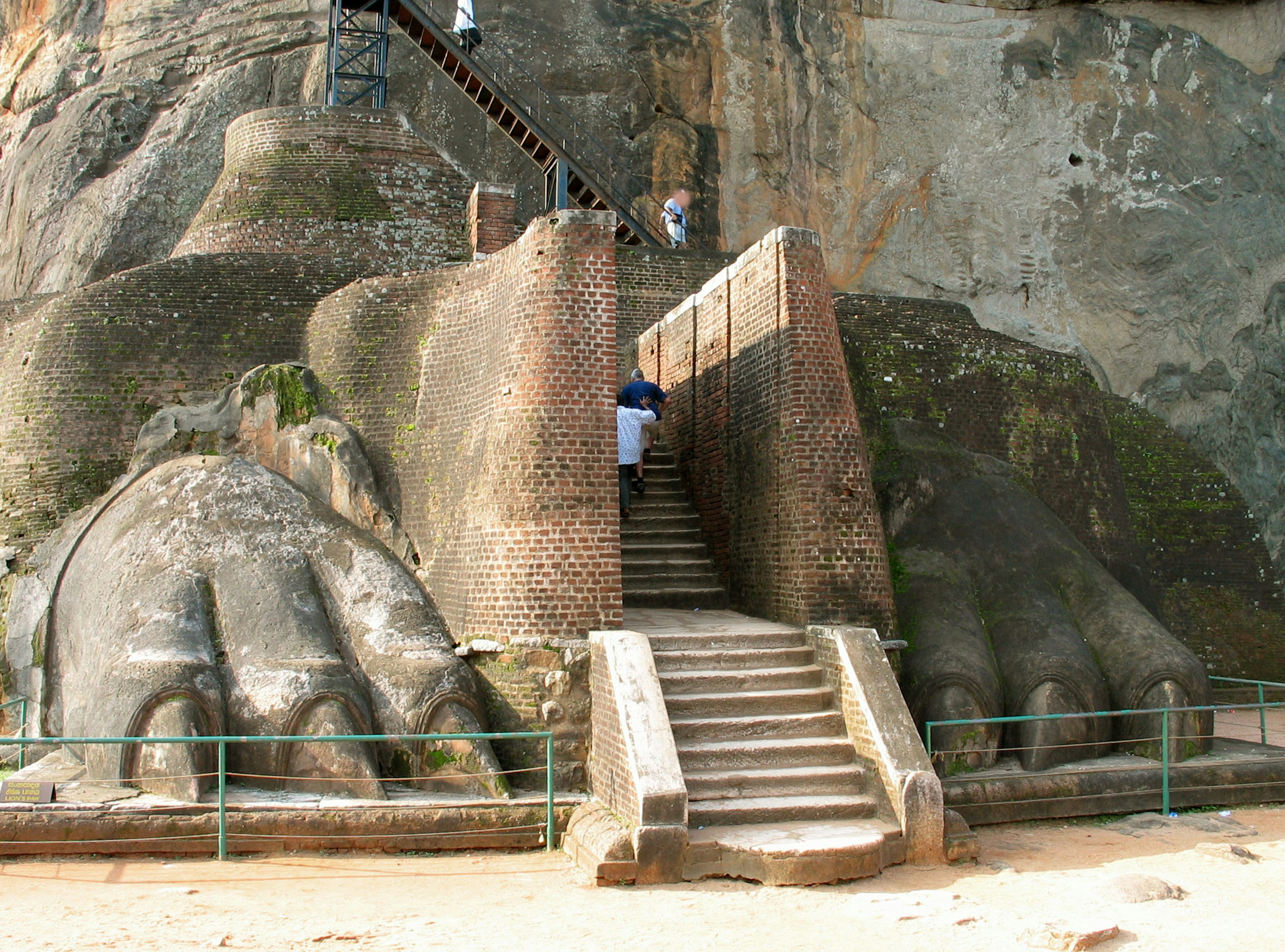 Staircase leading up to a large rock formation with prominent hands