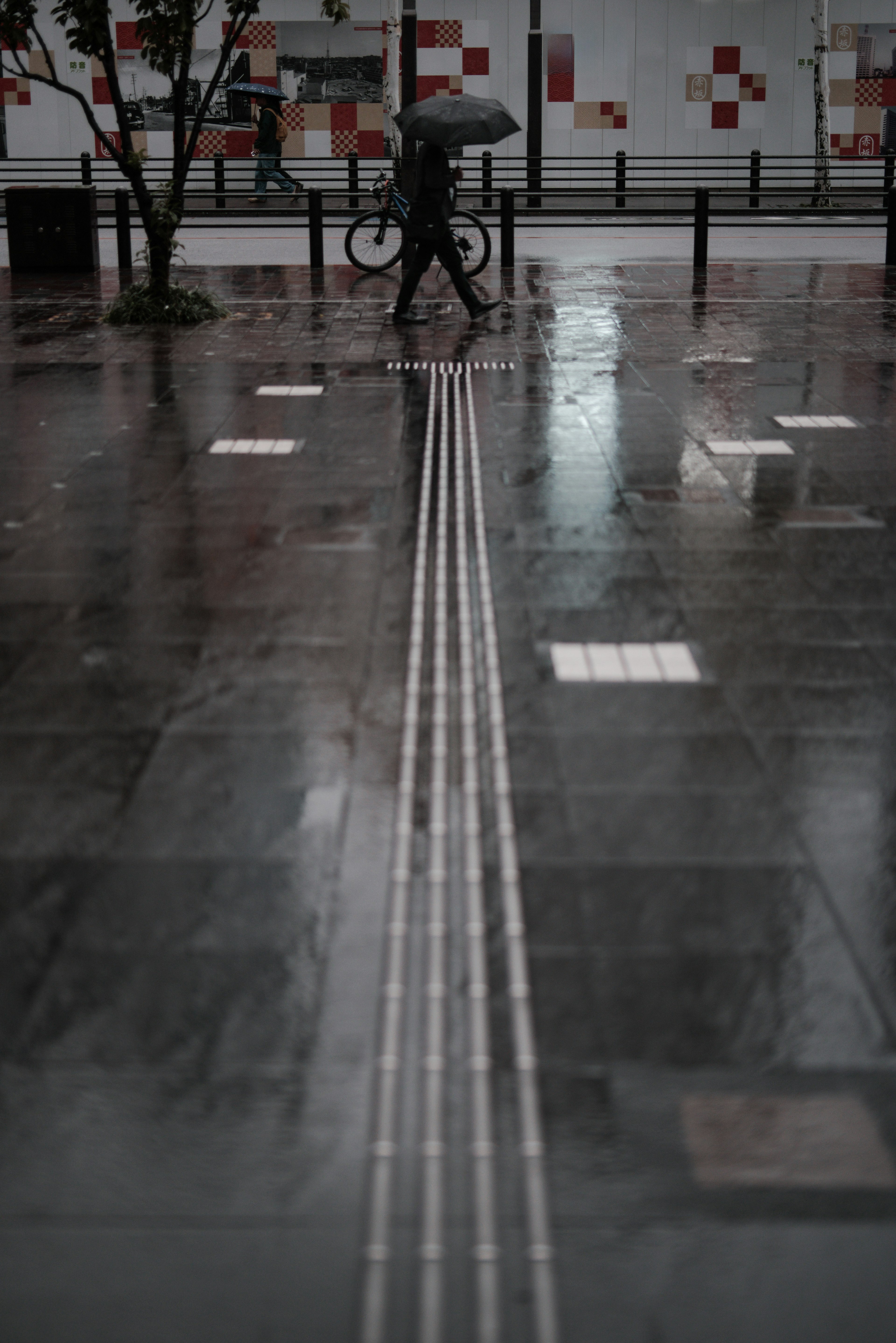 Personne marchant avec un parapluie sur un pavé mouillé