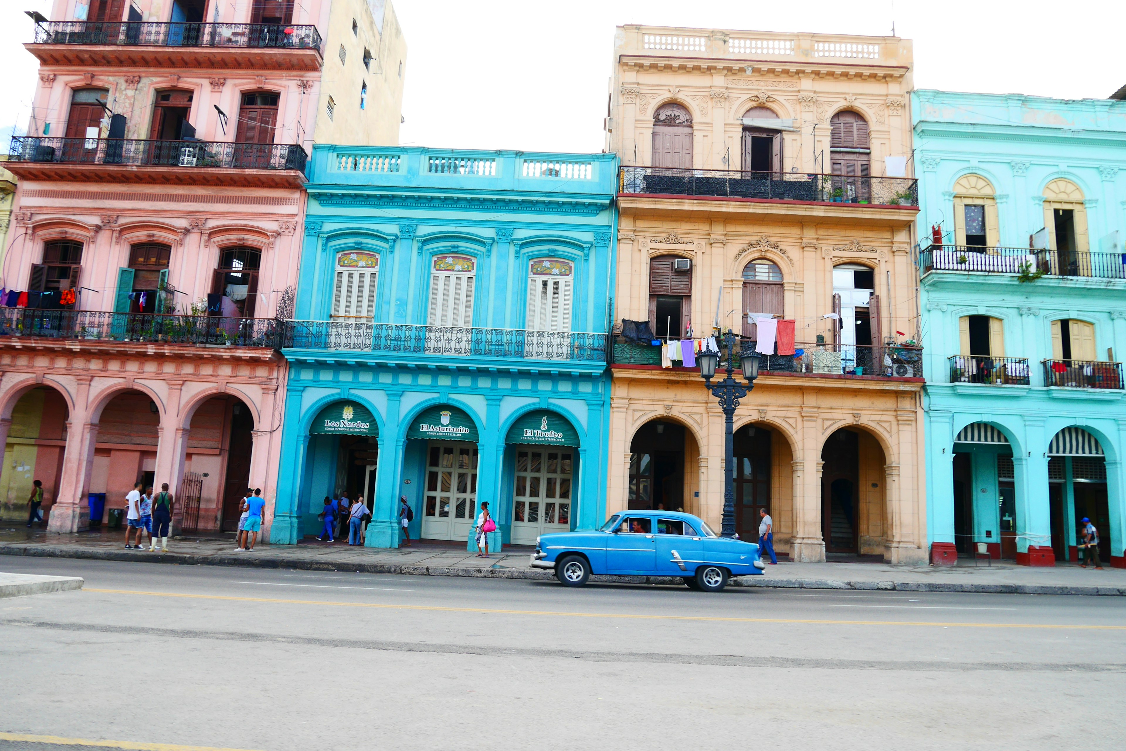 Edificios coloridos a lo largo de una calle en La Habana con un auto clásico