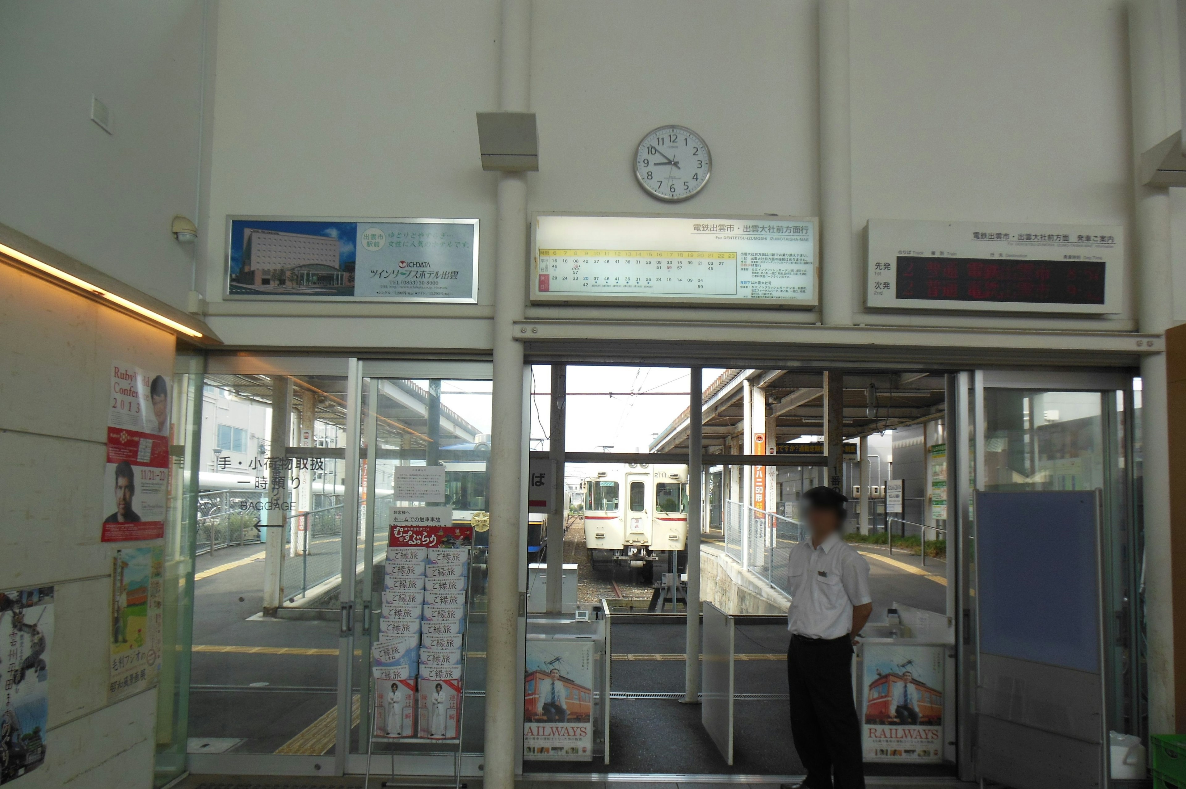 Train station entrance with clock and visible train