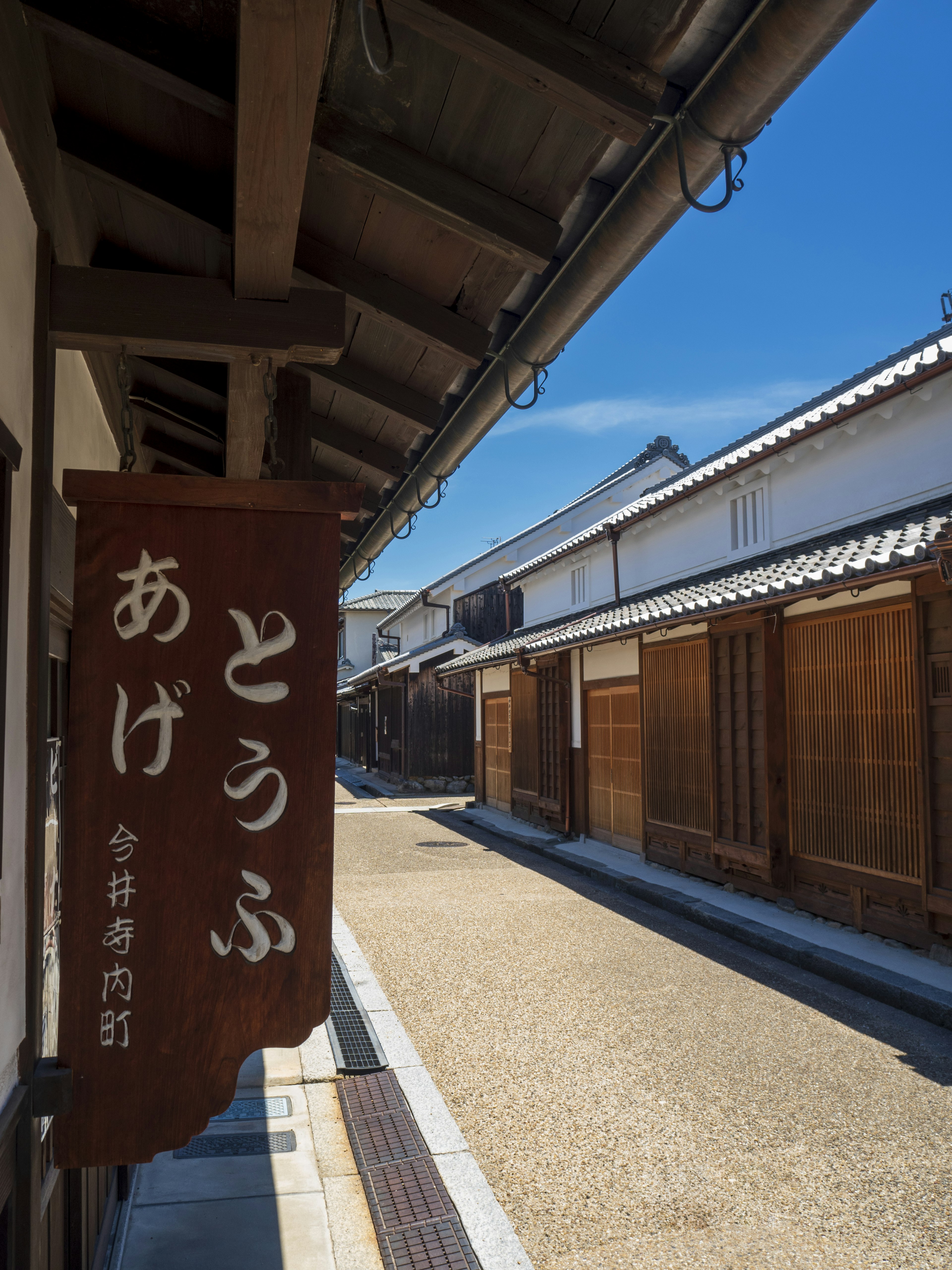 伝統的な日本の街並みと青空の下にあるとうふの看板