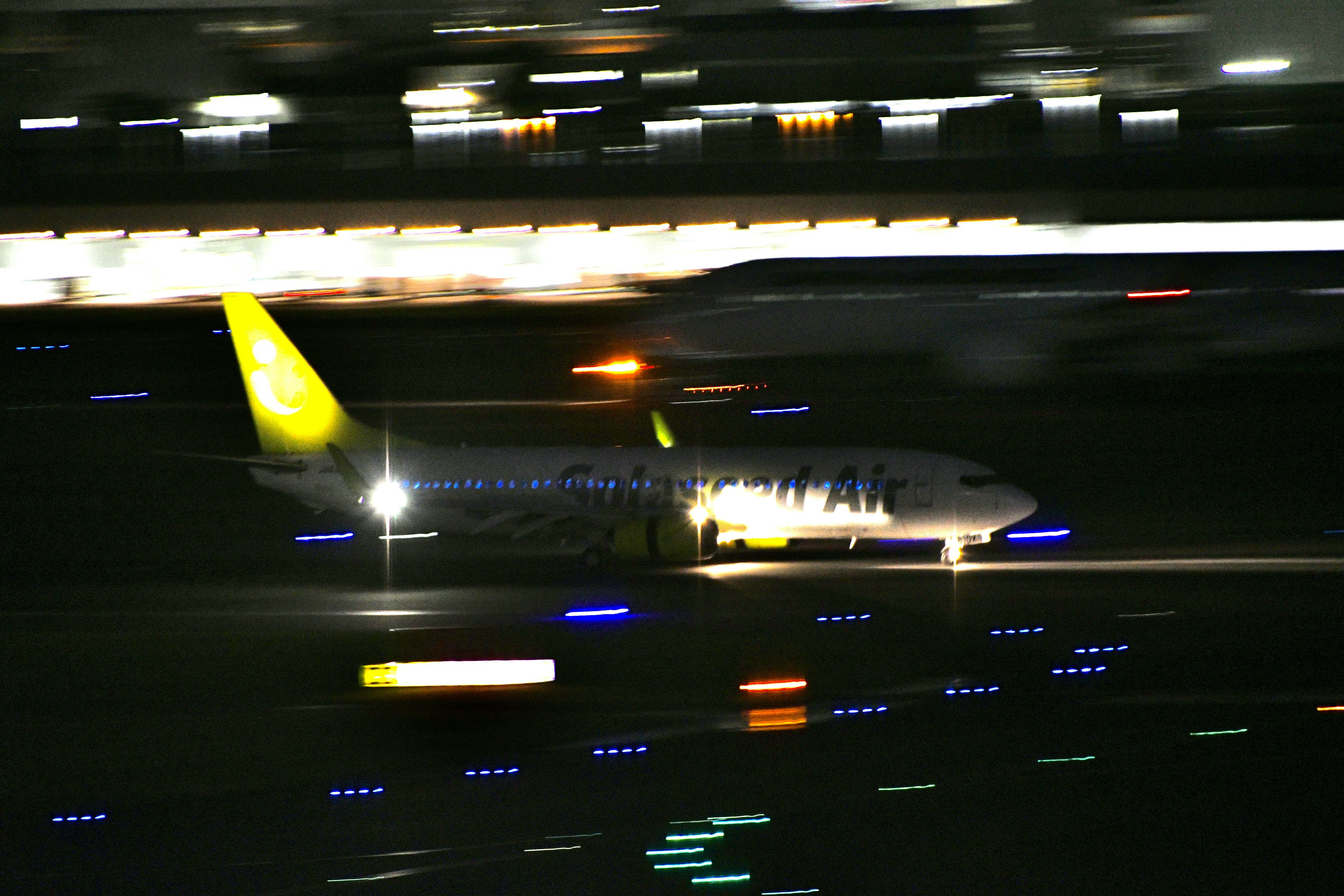 Una imagen clara de un avión rodando en una pista de noche