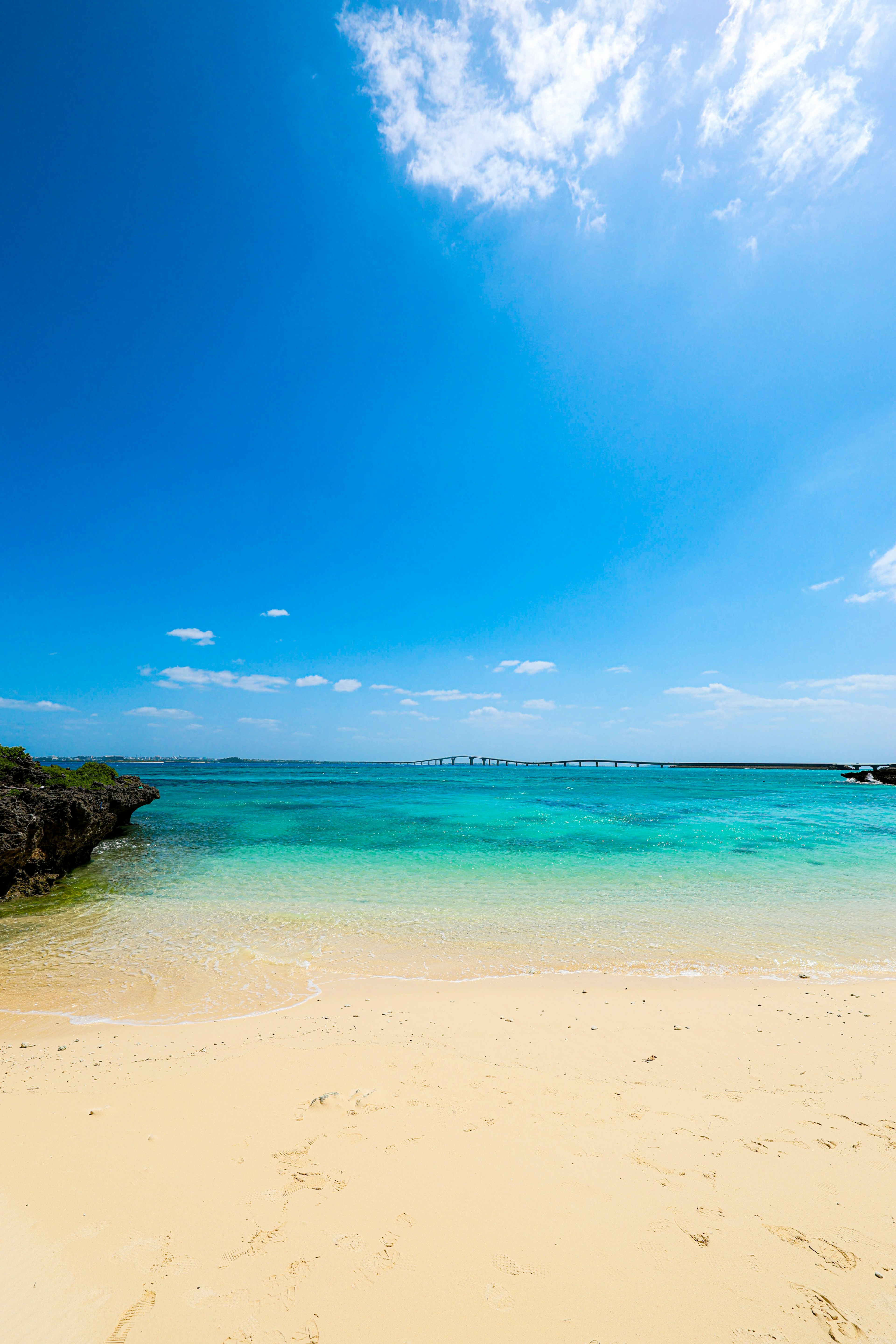 Escena de playa con cielo azul y agua turquesa clara