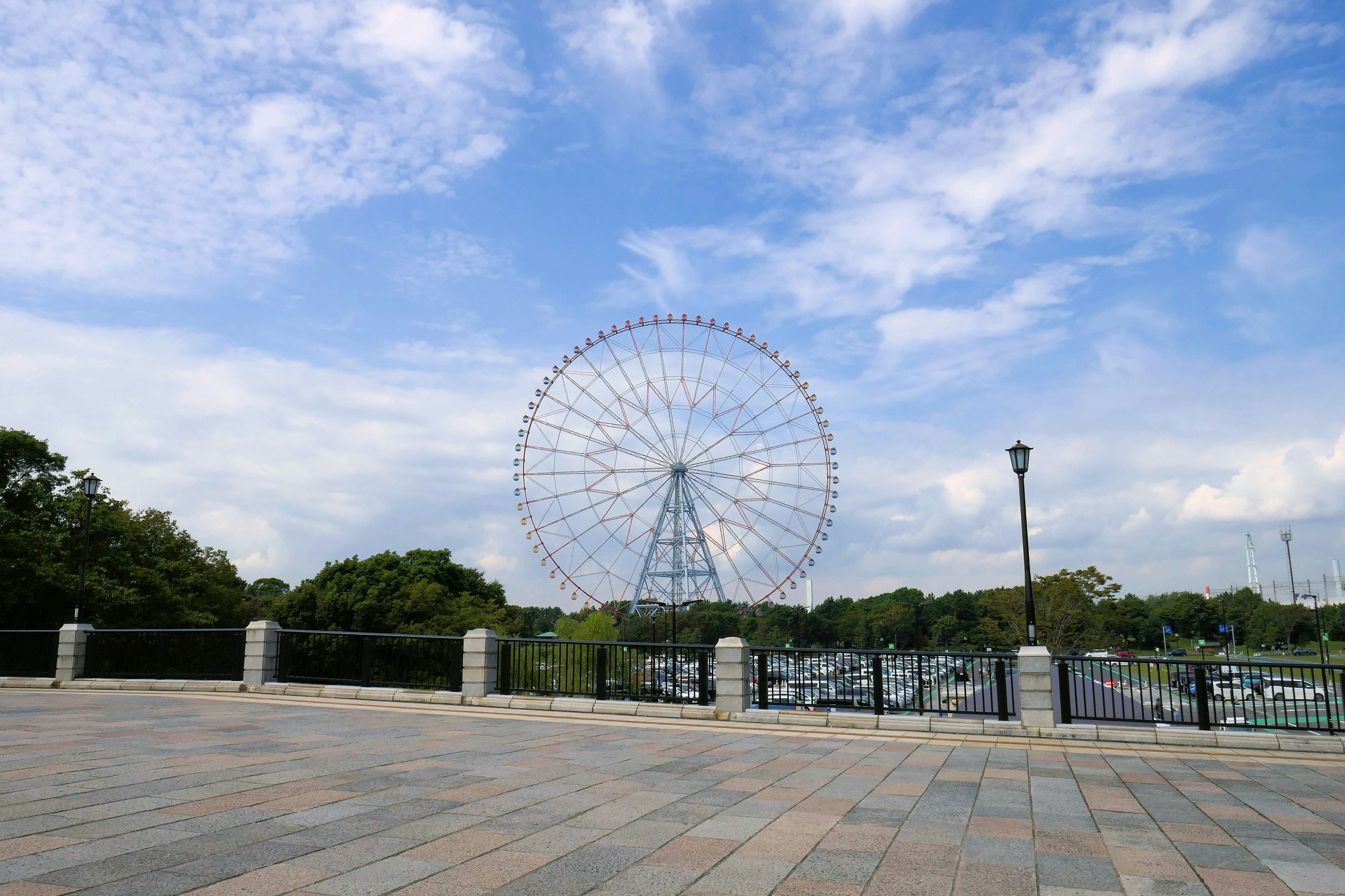 Grande ruota panoramica in un parco sotto un cielo blu