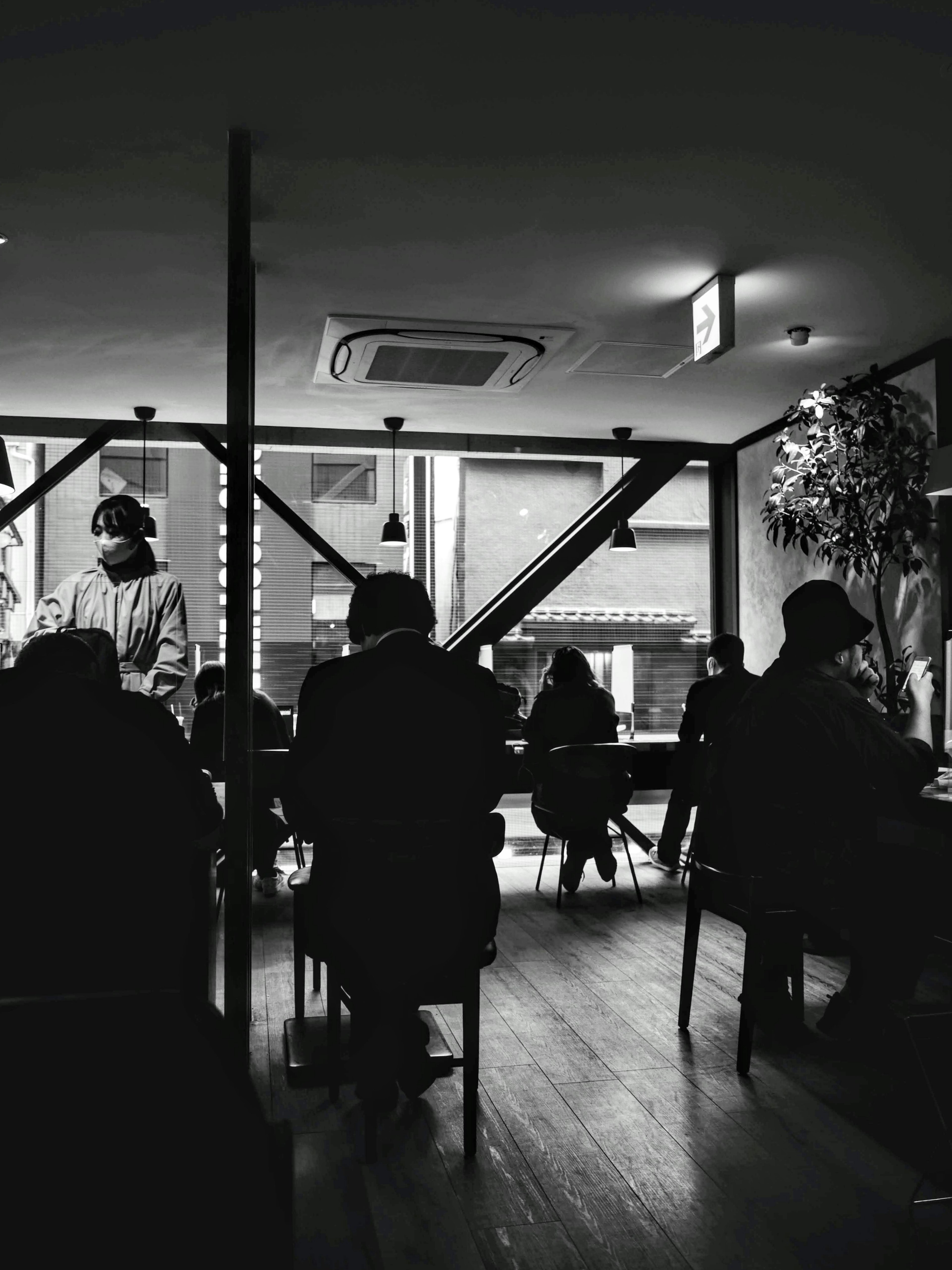 Intérieur d'un café faiblement éclairé avec des gens assis Personnel prenant des commandes