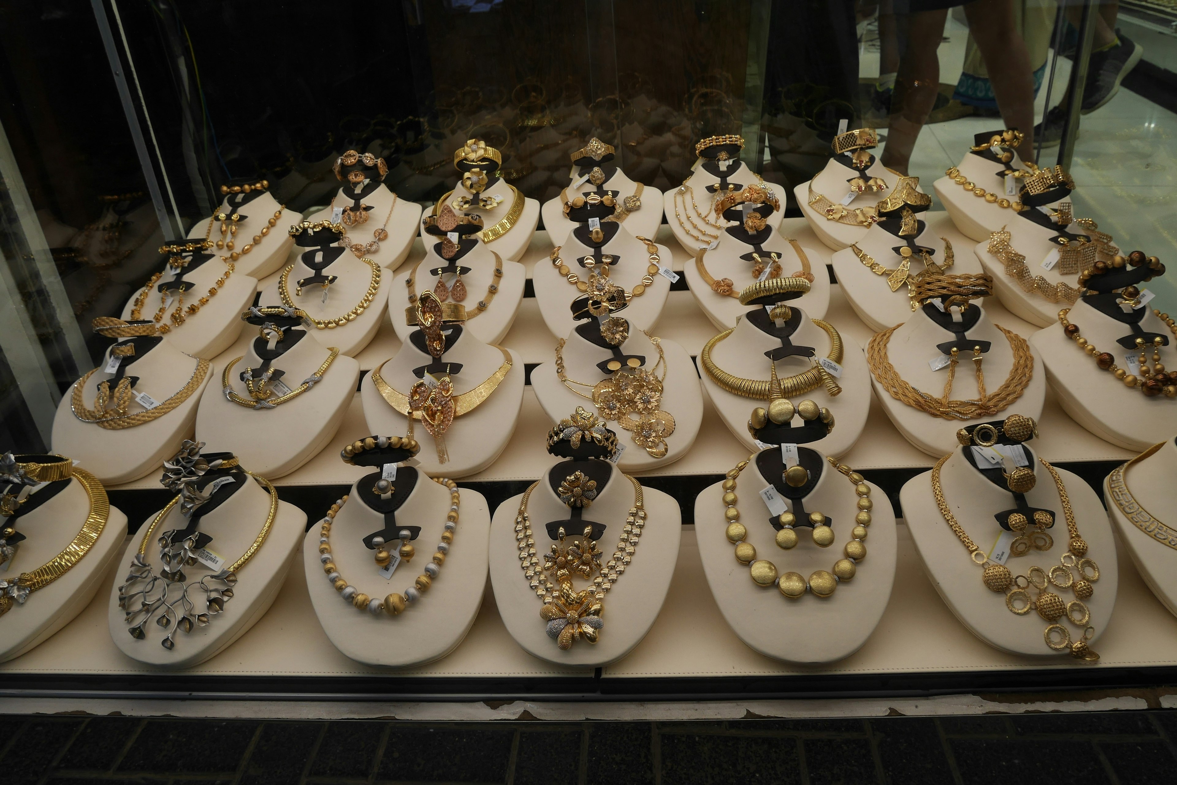 Différents colliers et bijoux exposés dans la vitrine d'une bijouterie