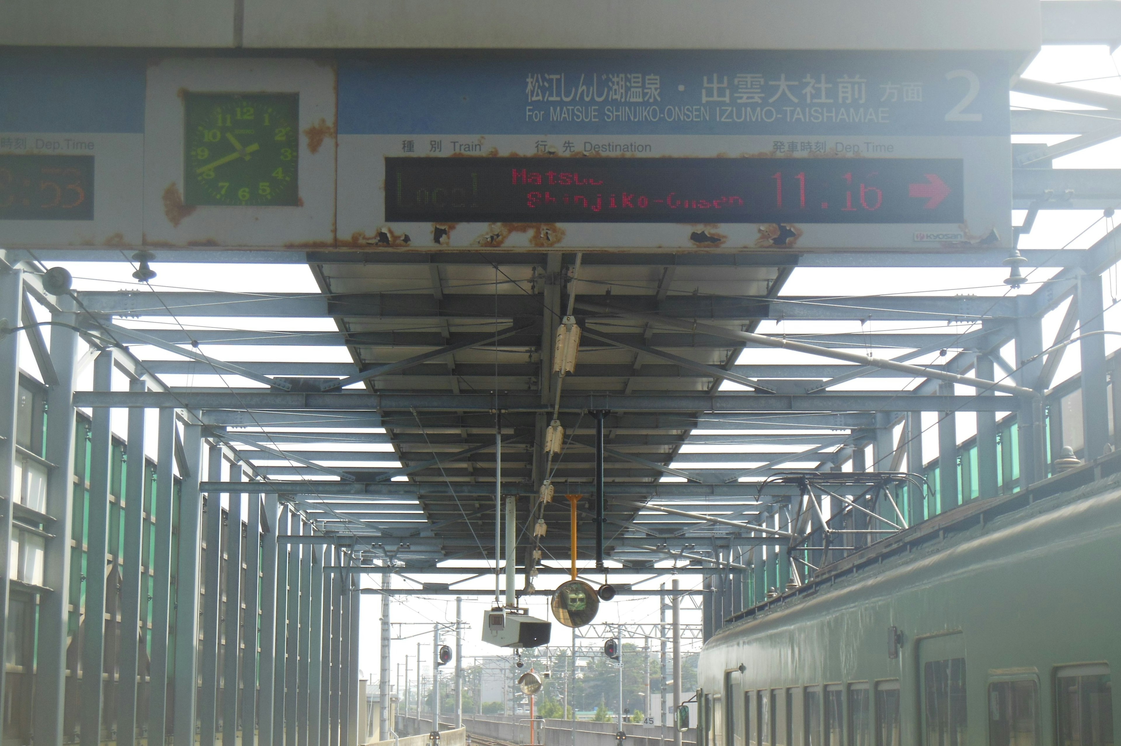 駅のプラットフォームの上にあるデジタル表示板と照明器具