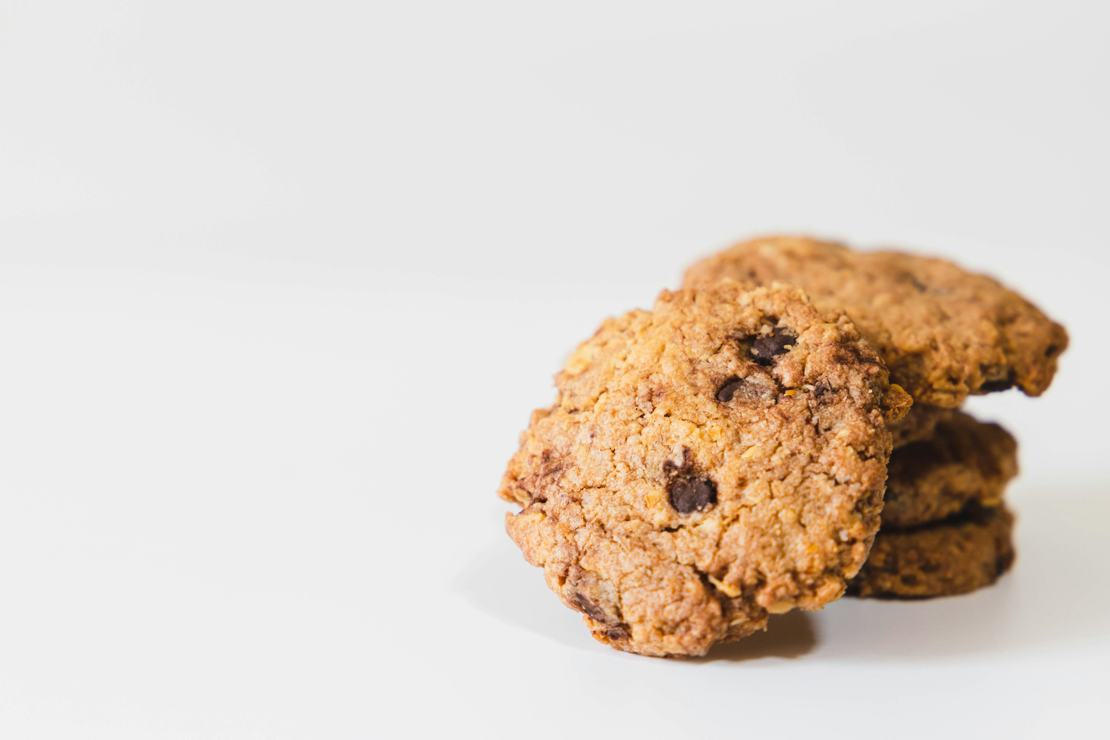 A stack of chocolate chip cookies on a plain background