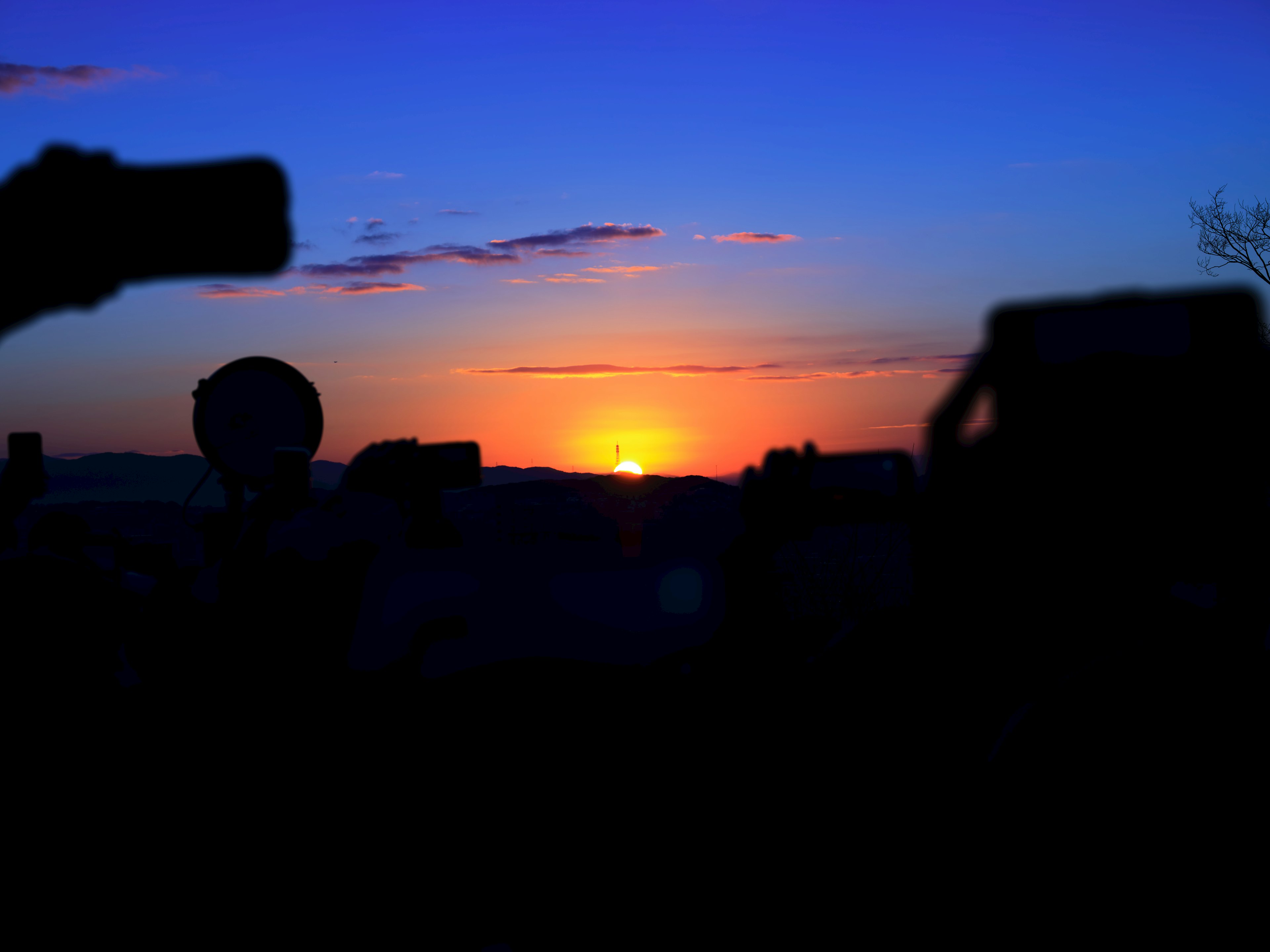 Silhouetten von Fotografen, die einen schönen Sonnenuntergang mit lebhaften Farben festhalten